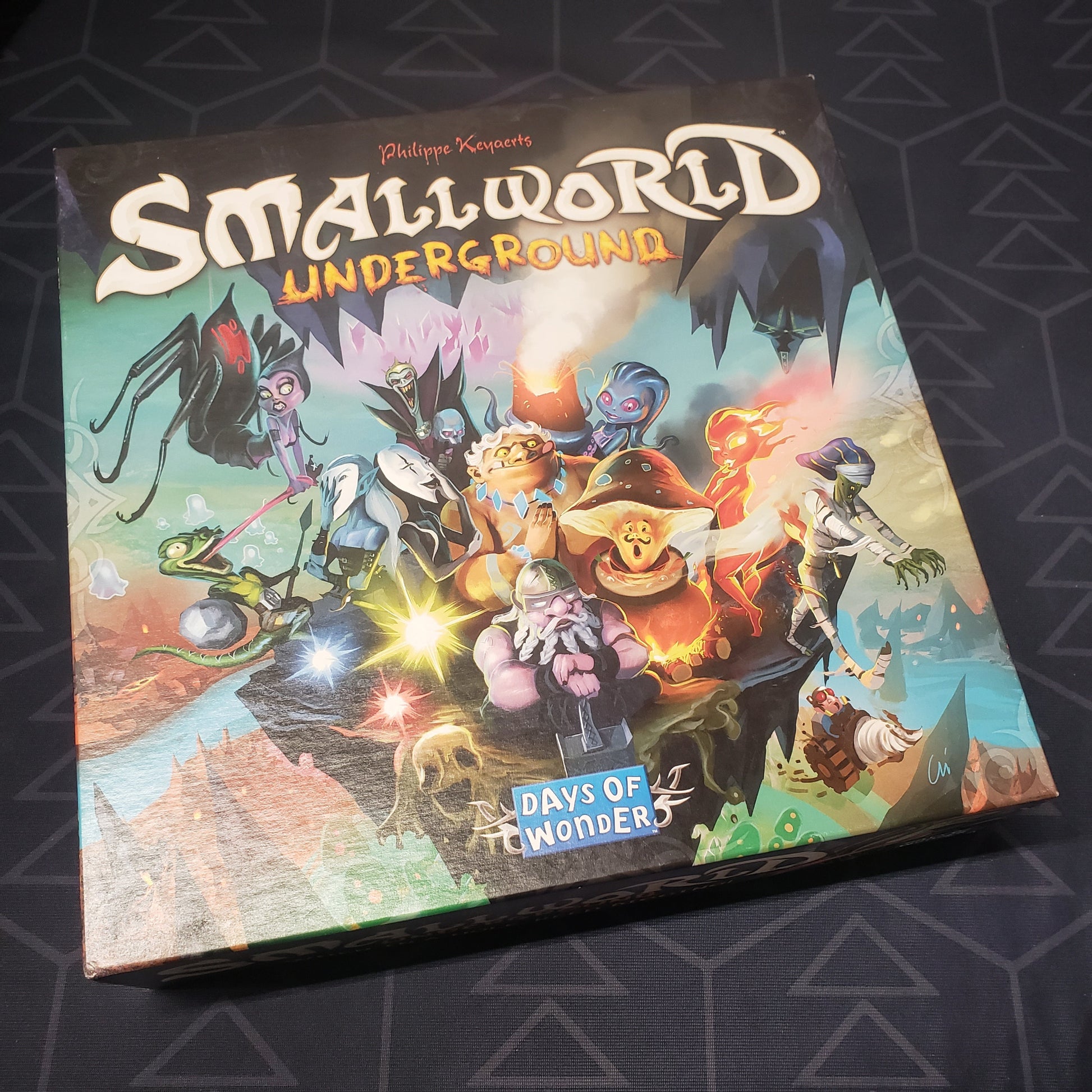 Image shows the front cover of the box of the Small World Underground board game