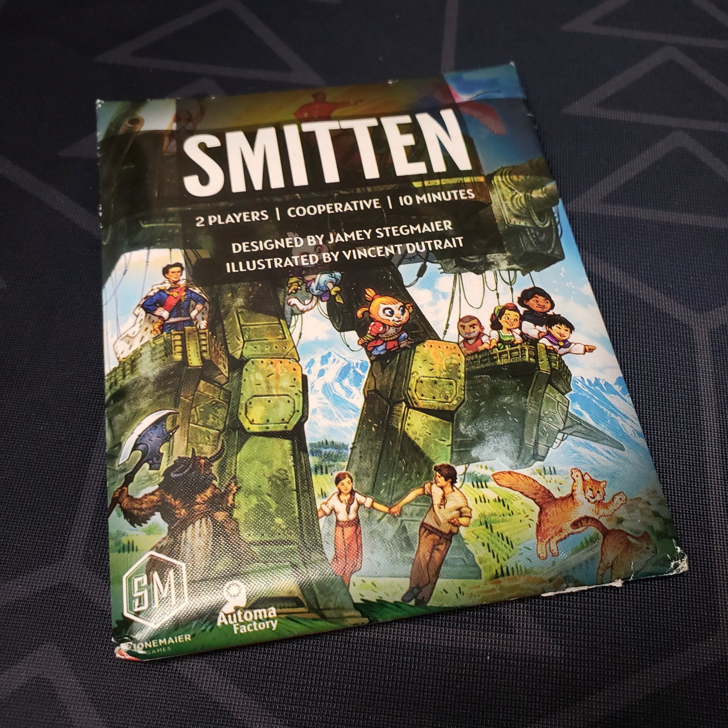 Image shows the front of the packaging for the Smitten card game