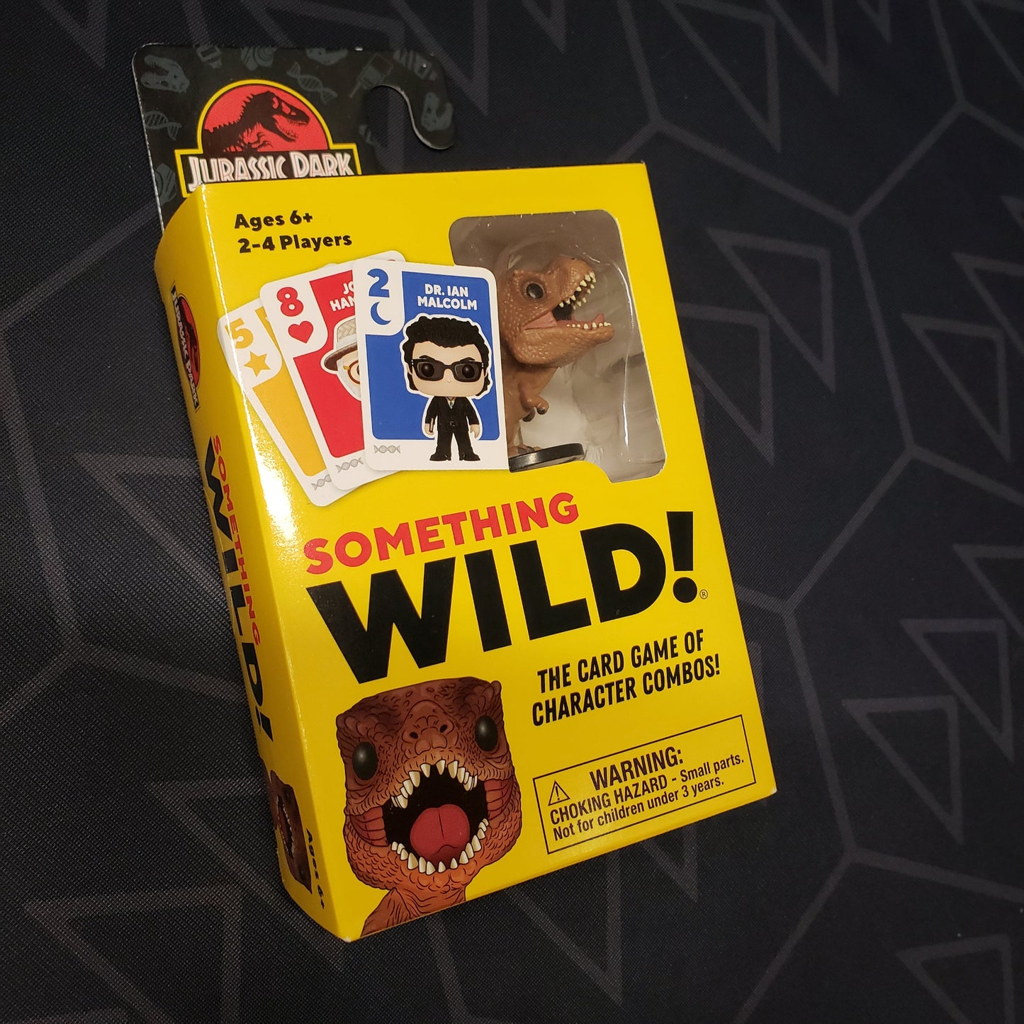 Image shows the front cover of the box of the Something Wild!: Jurassic Park card game