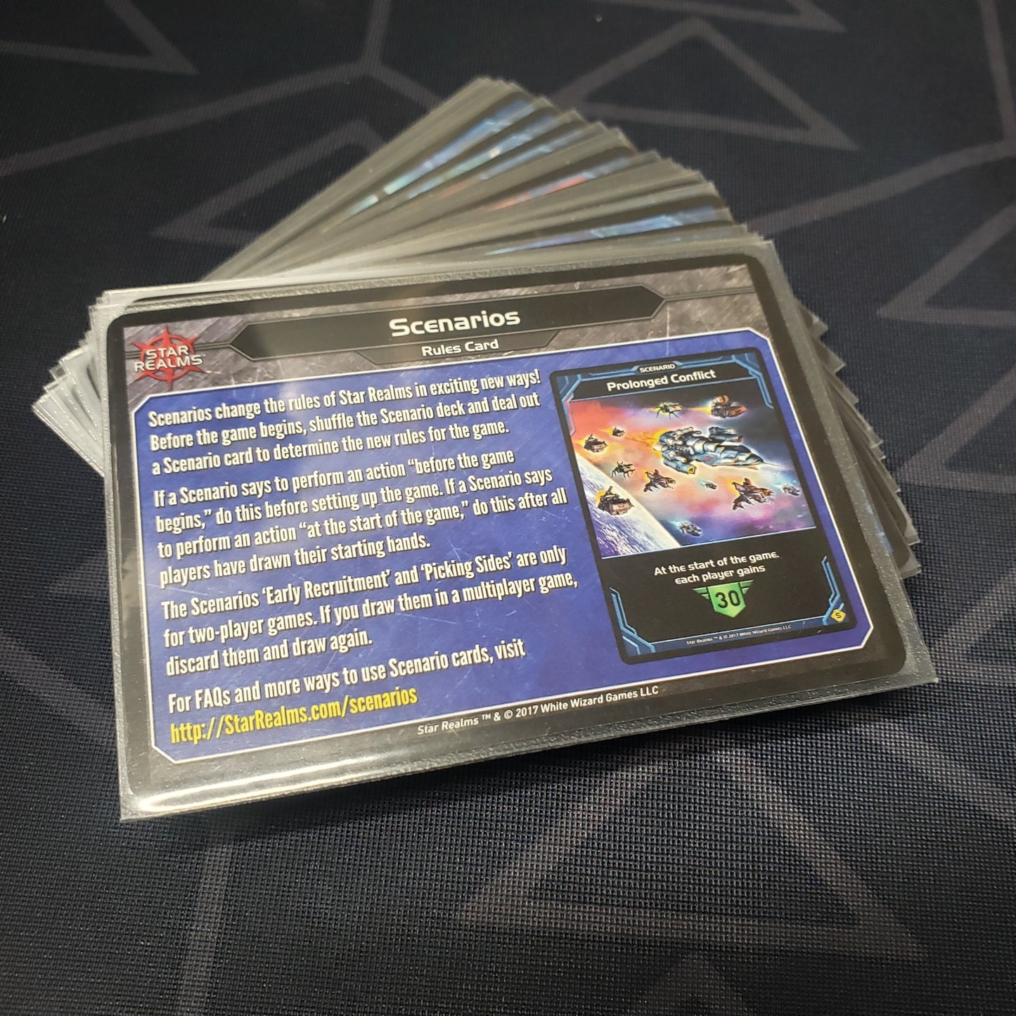Image shows the cards for the Scenarios expansion for the card game Star Realms fanned out in a stack