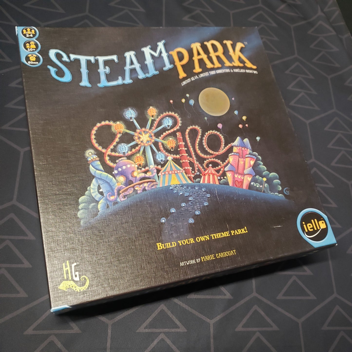 Image shows the front cover of the box of the Steam Park board game