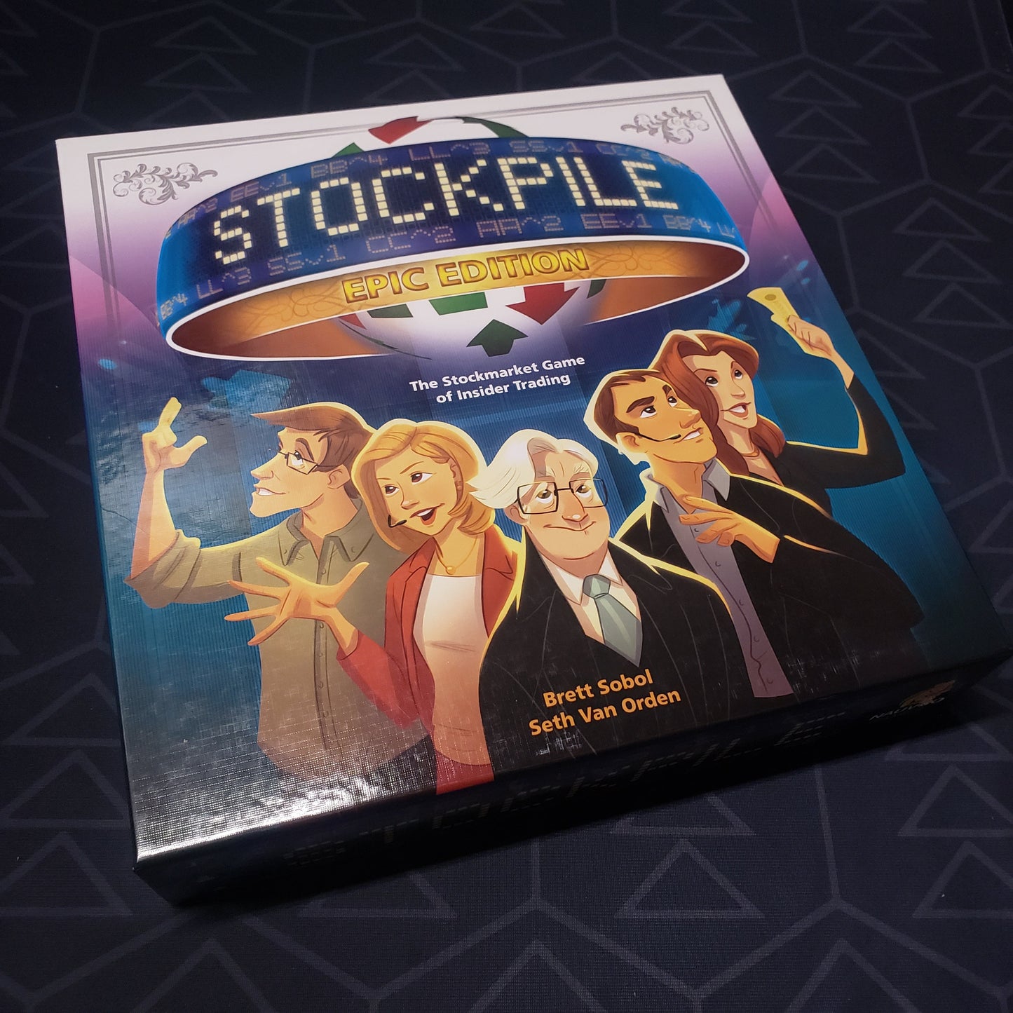Image shows the front cover of the box for the Stockpile: Epic Edition board game
