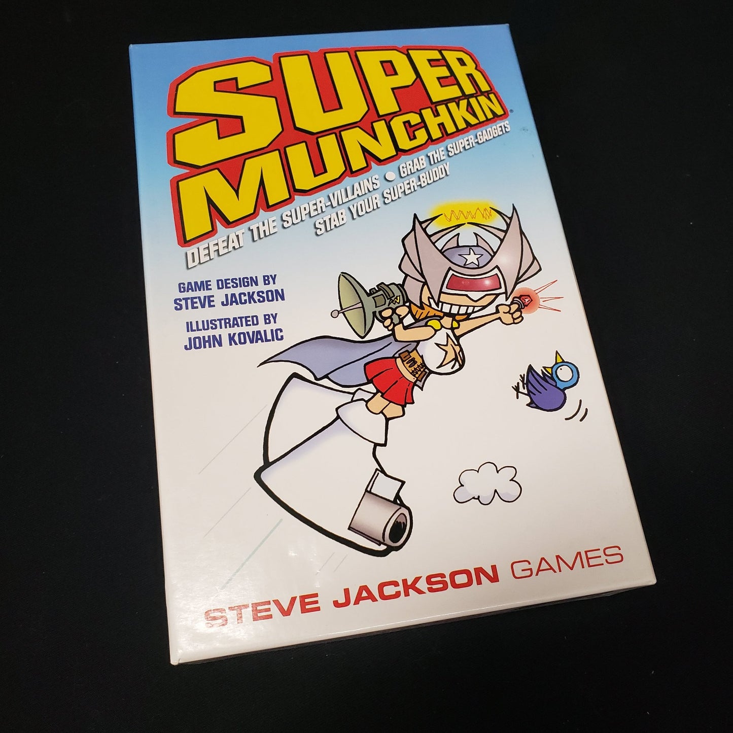 Image shows the front cover of the box of the Super Munchkin coard game