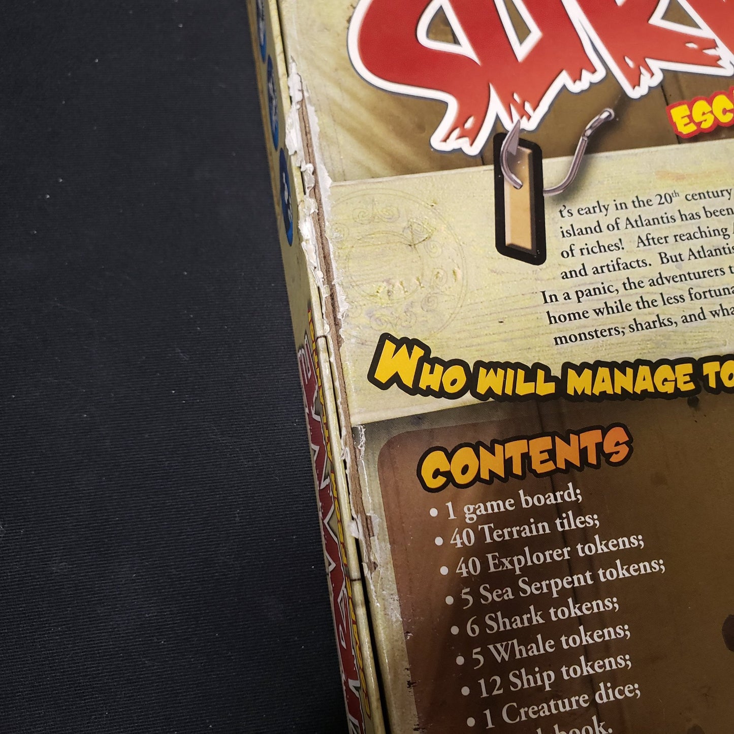 Image shows some box damage along the bottom of the board game Survive: escape From Atlantis