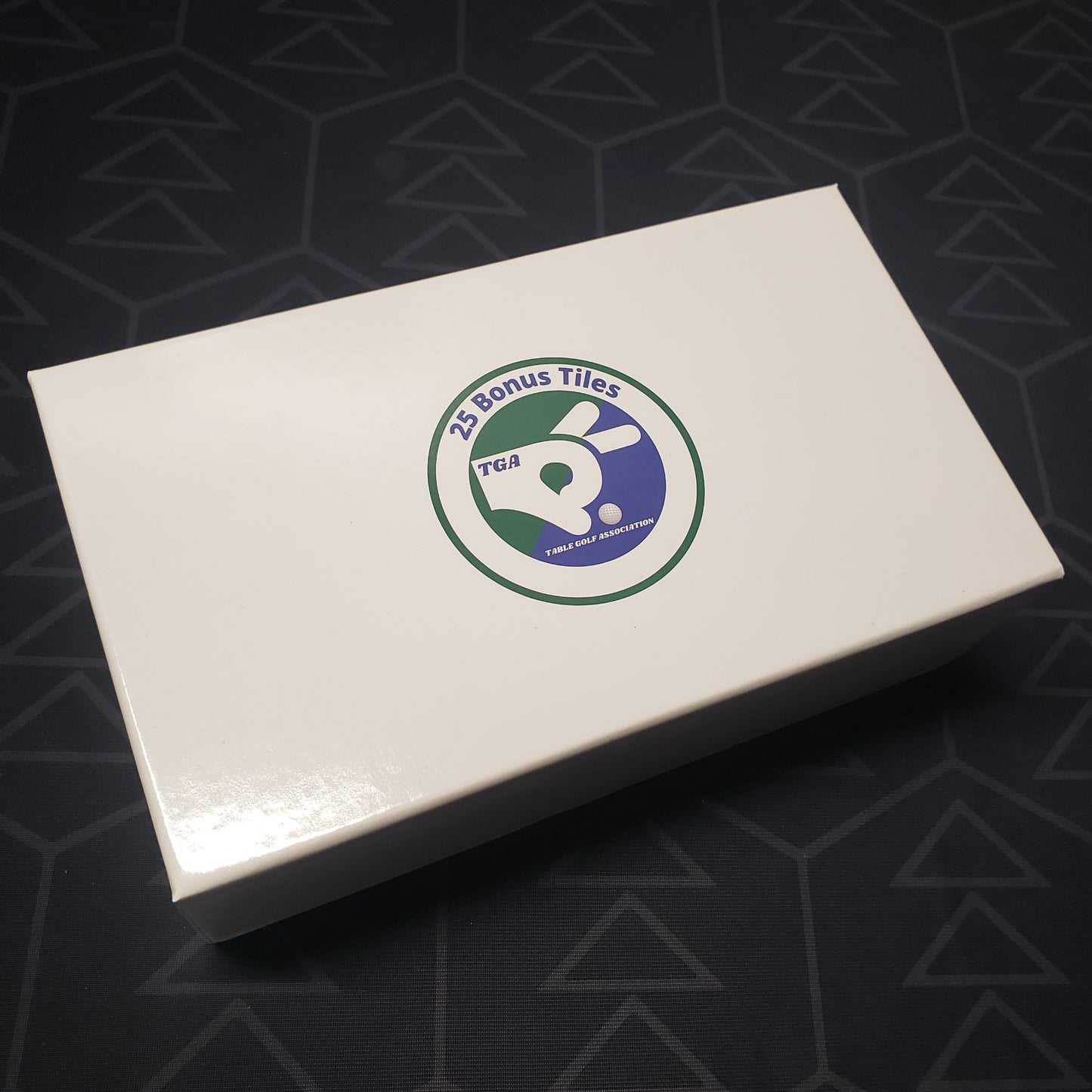 Image shows the front cover of the box of the 25 Bonus Tiles expansion for the board game Table Golf Association