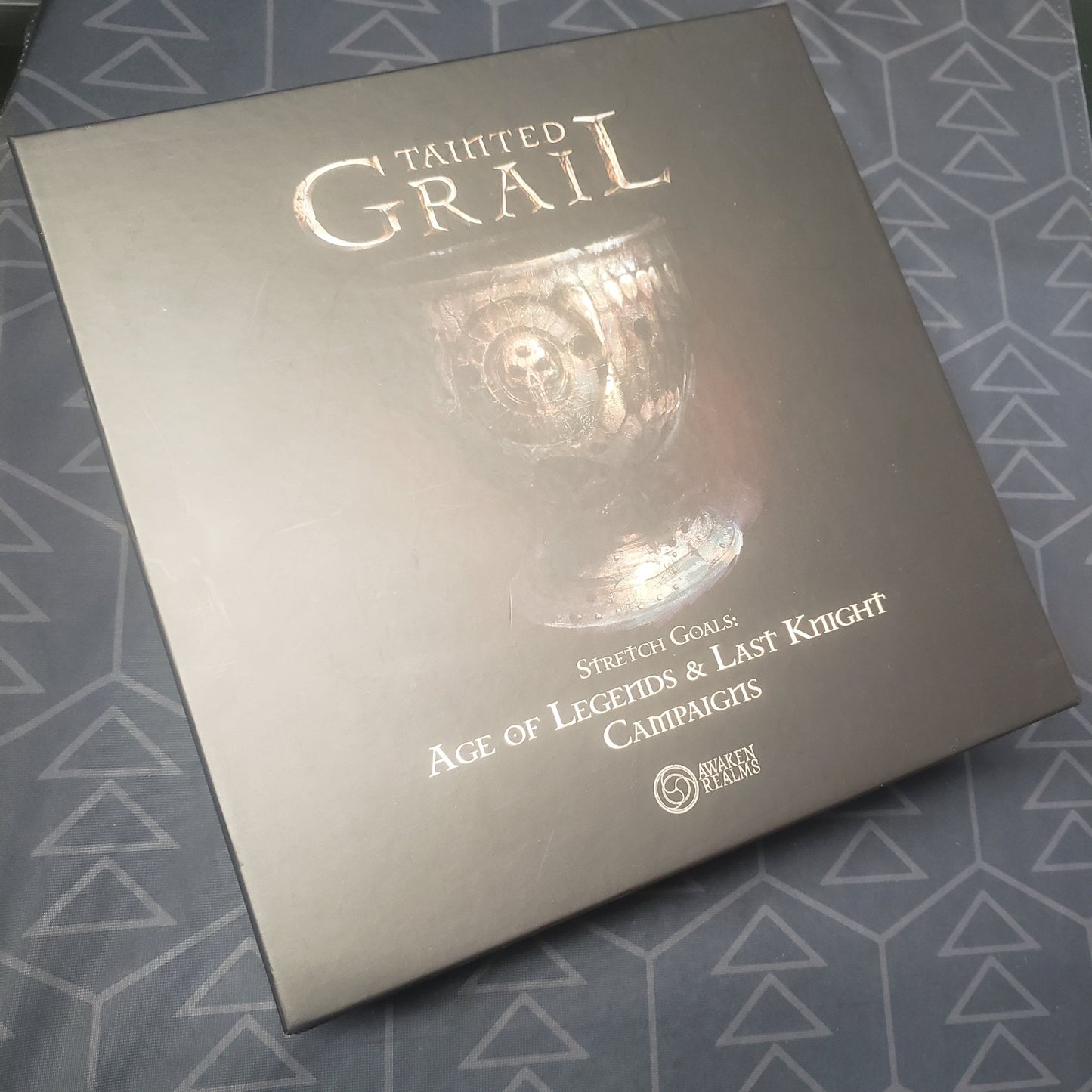 Image shows the front cover of the box of the Age of Legends & Last Knight Campaigns expansion for the board game Tainted Grail