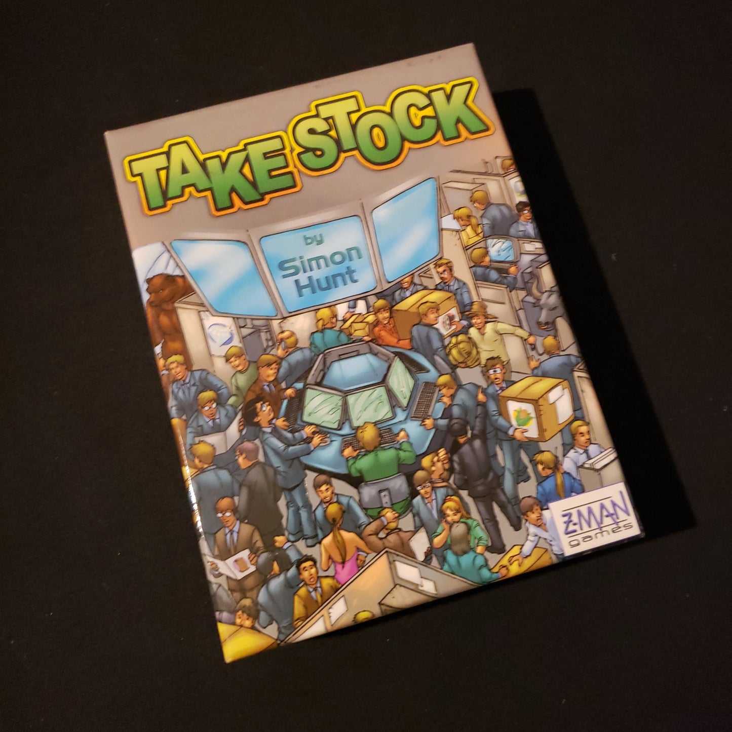 Image shows the front cover of the box of the Take Stock card game