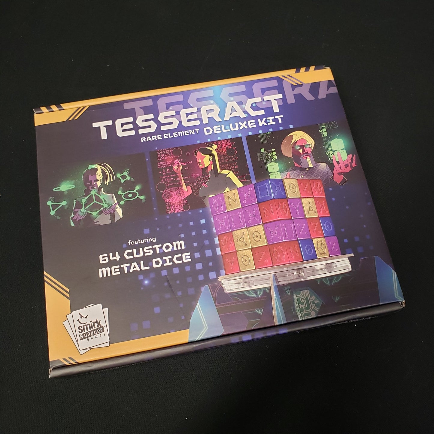 Image shows the front cover of the box of the Rare Element Deluxe Metal Dice Kit for the board game Tesseract