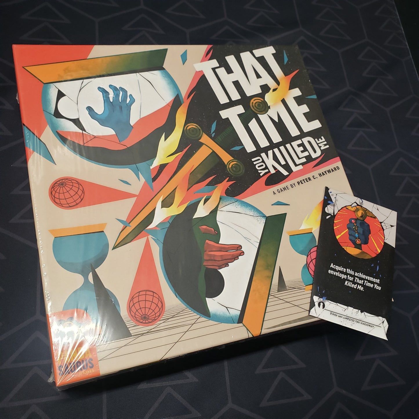 Image shows the front cover of the box of the That Time You Killed Me board game with a promo pack sitting on top of it