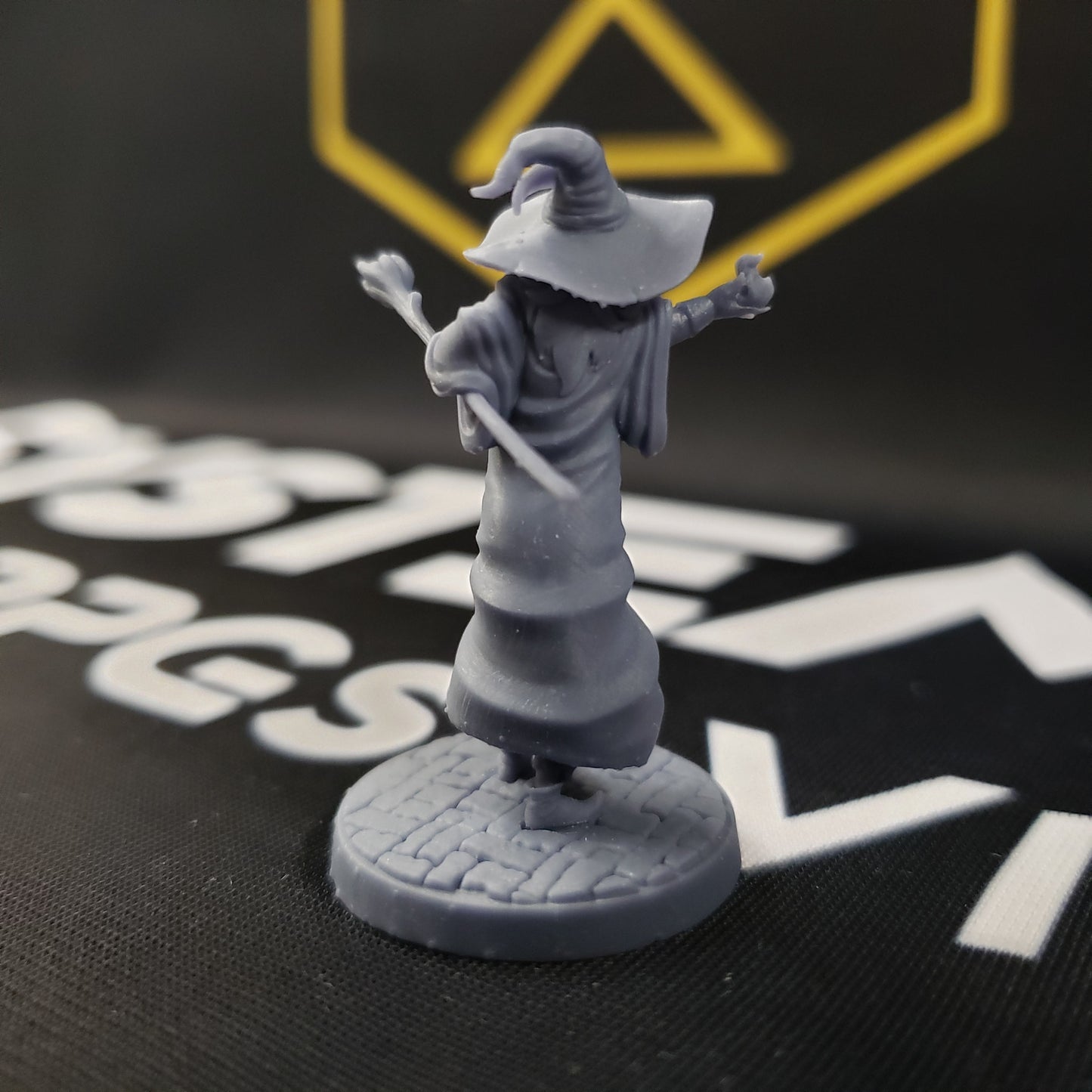 Image shows the back of a gaming miniature of a wizard that is three gnomes in a trenchcoat