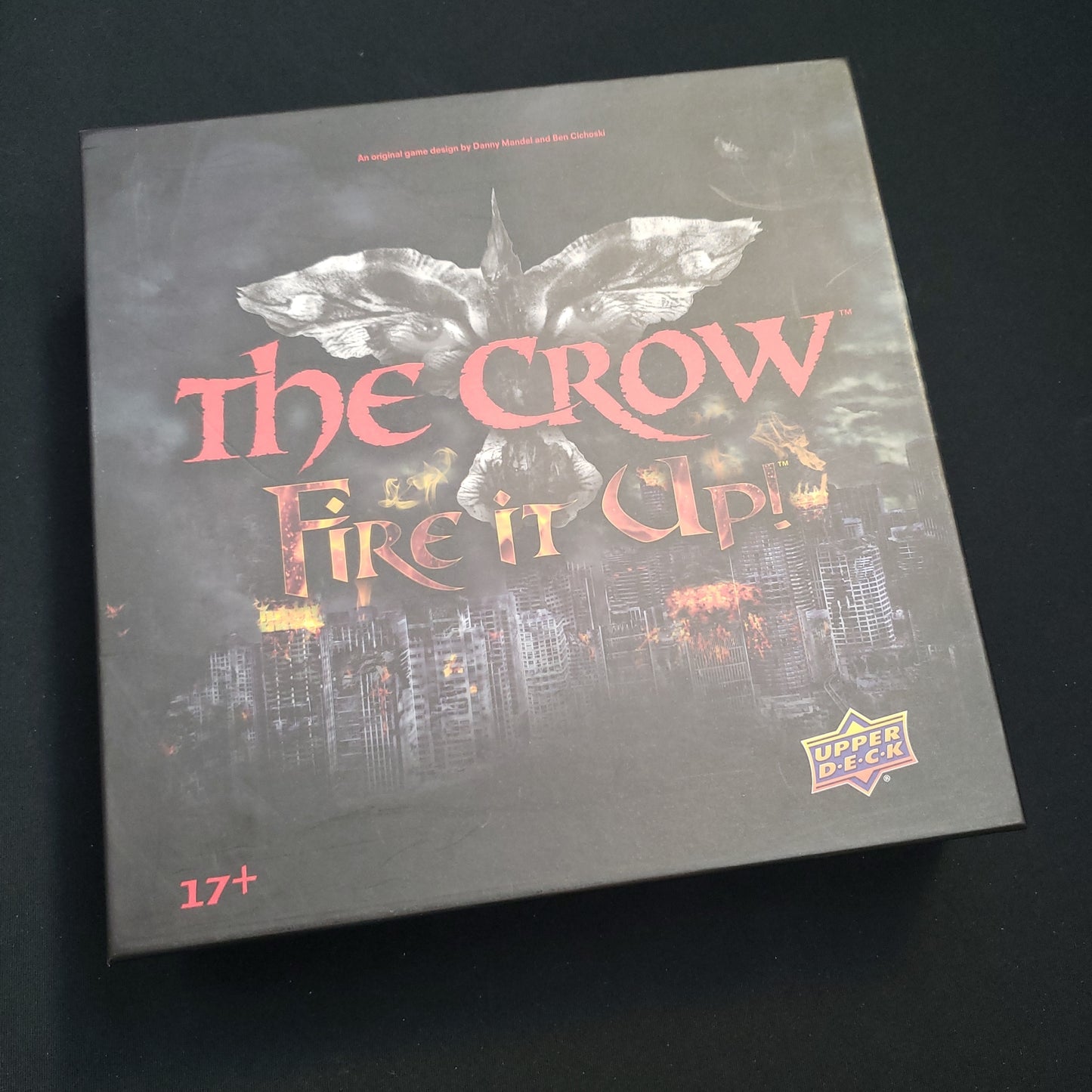 Image shows the front cover of the box of the Crow: Fire It Up! board game