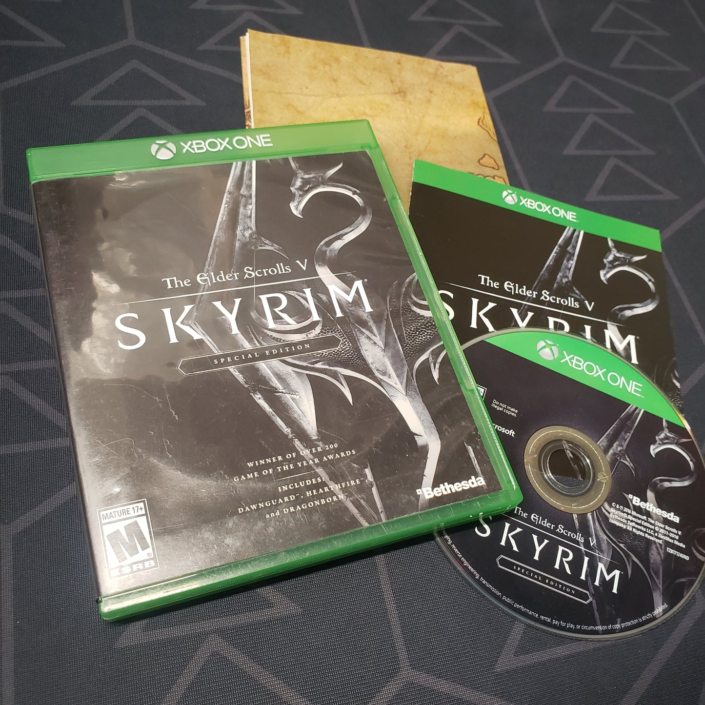 Image shows the case, manual, map and disc for the video game The Elder Scrolls V: Skyrim for Xbox One