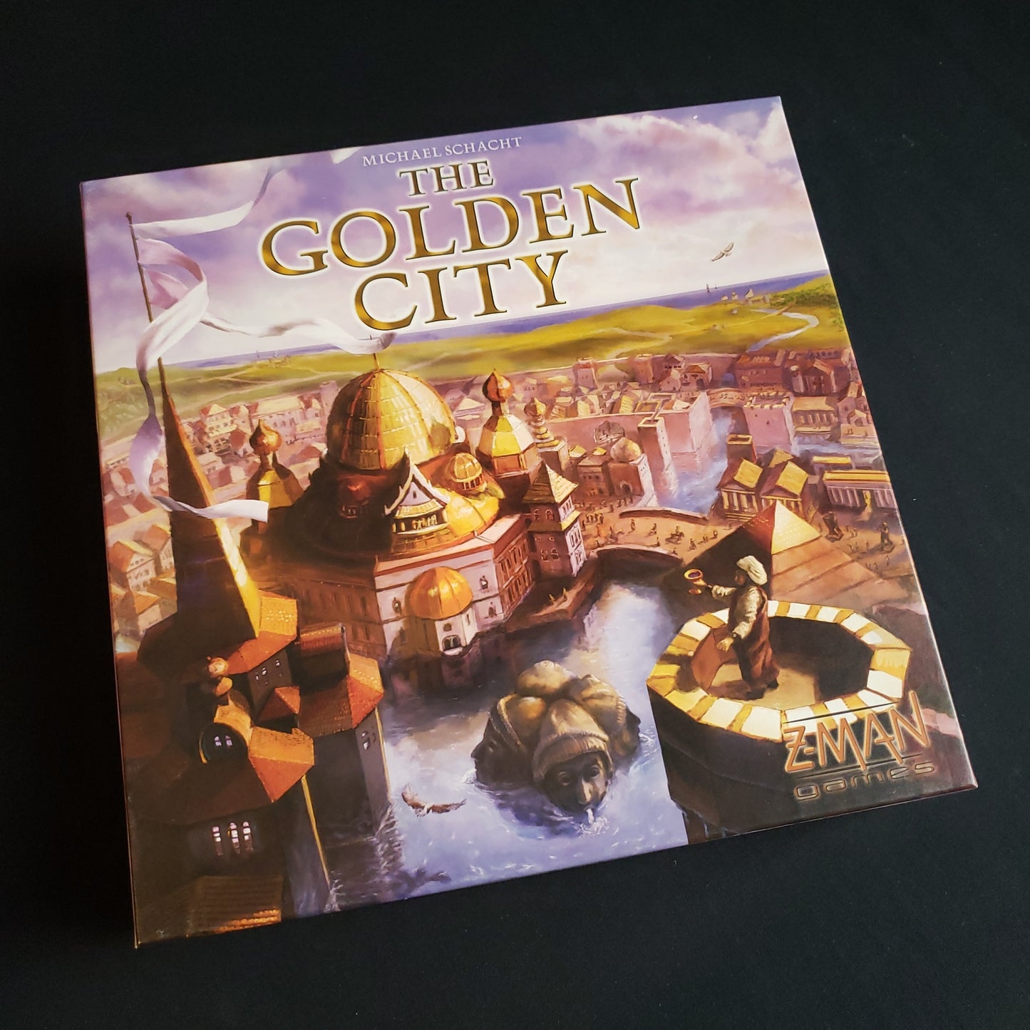 Image shows the front cover of the box of the Golden City board game