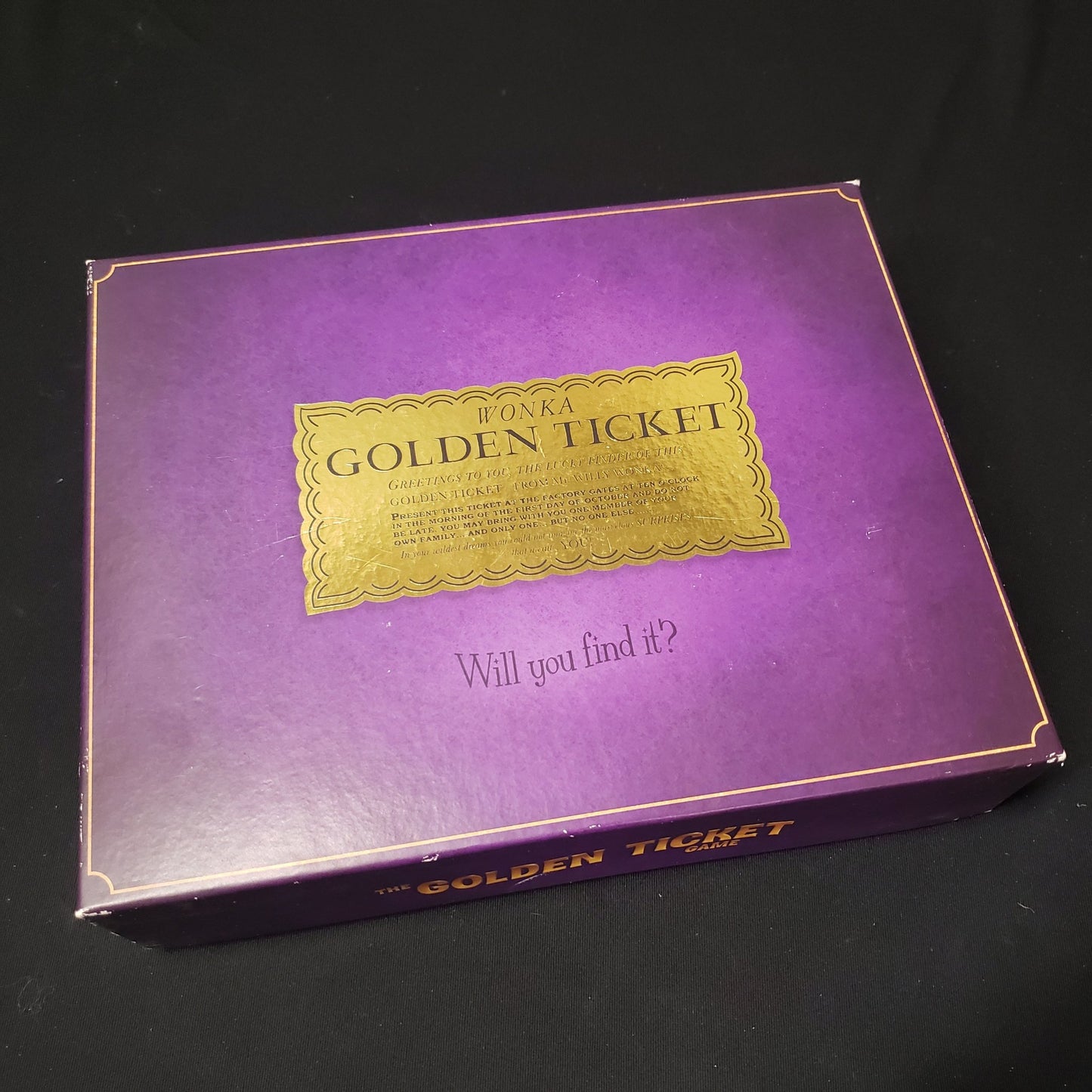 Image shows the front cover of the box of the Golden Ticket board game
