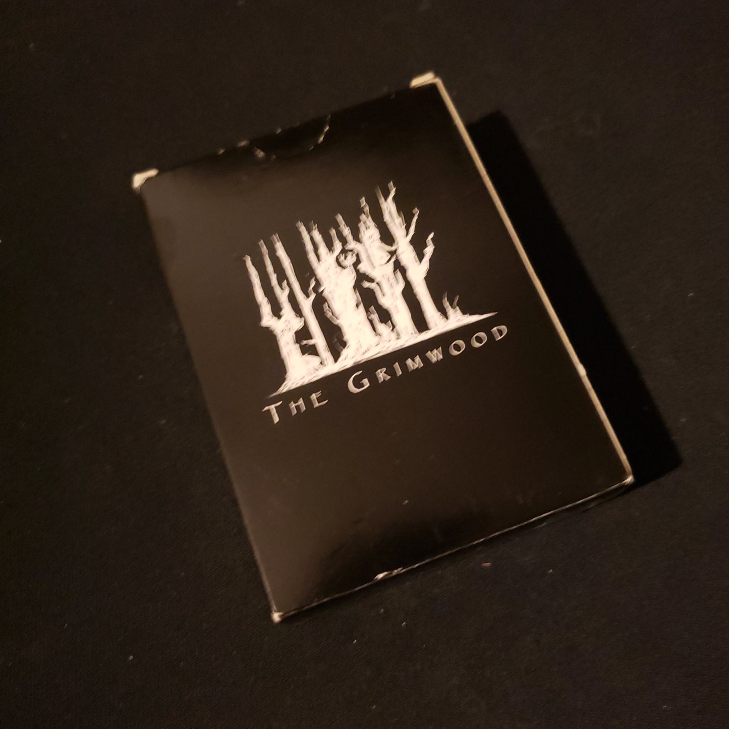 Image shows the front cover of the box of the Grimwood card game