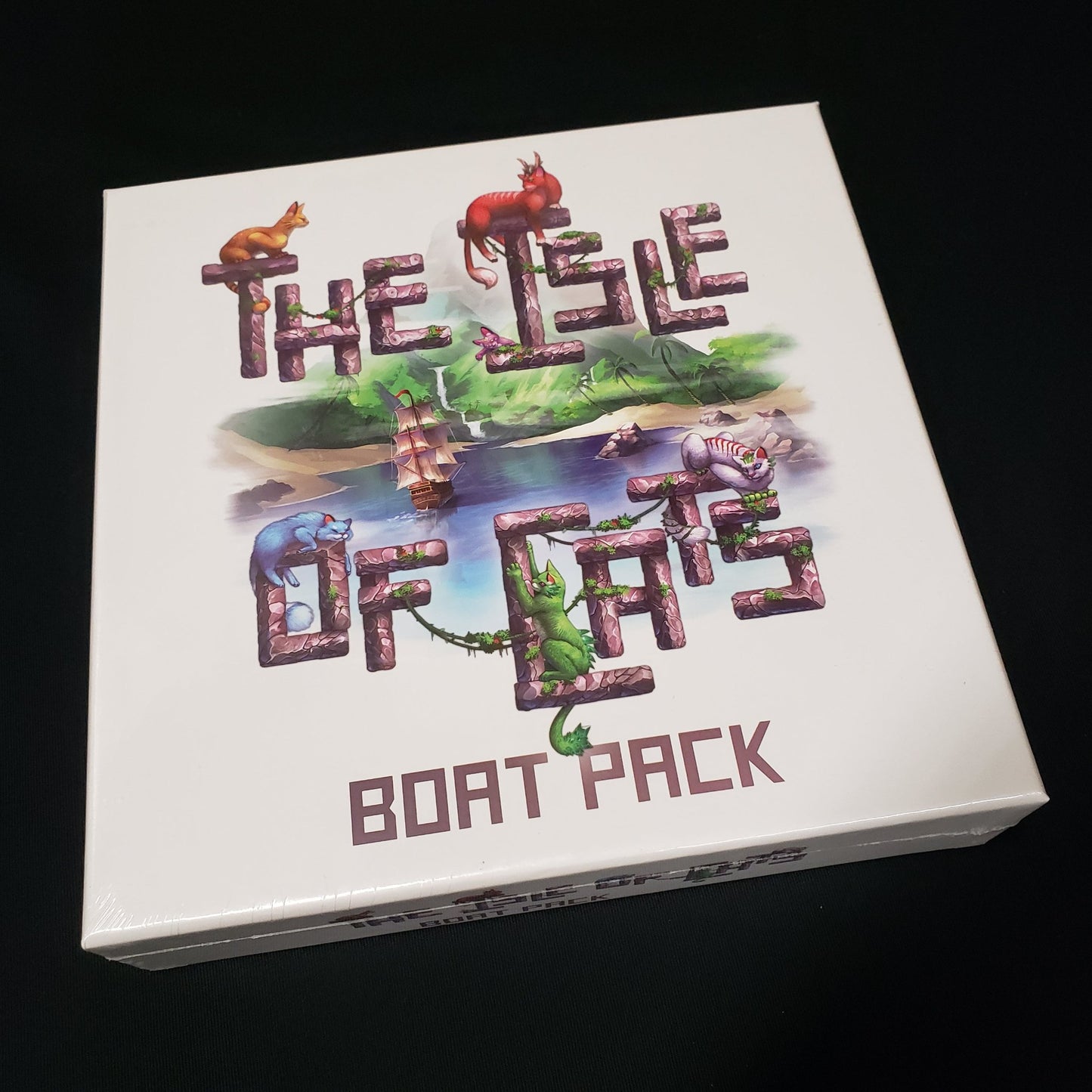 Image shows the front cover of the box of the Boat Pack expansion for the board game Isle of Cats
