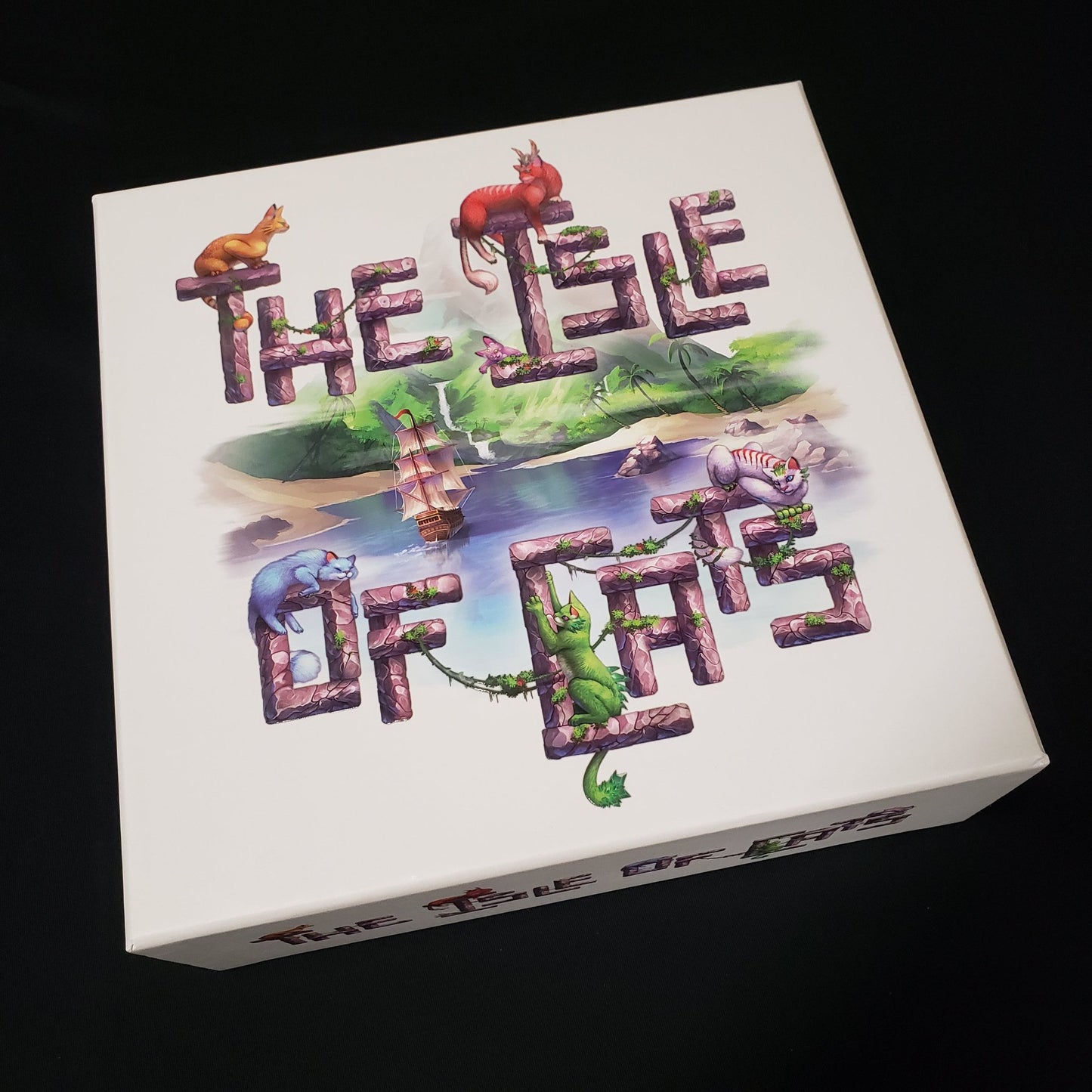 Image shows the front cover of the box of the Isle of Cats board game