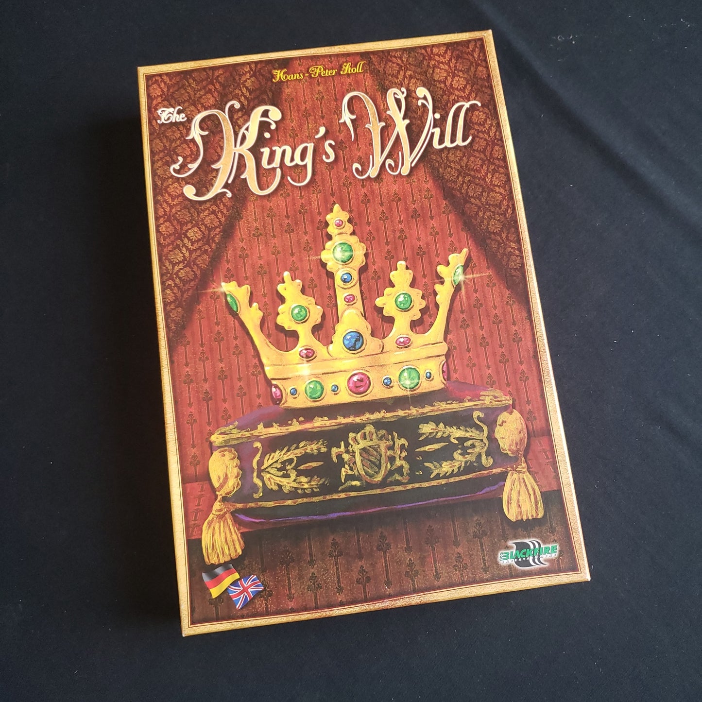Image shows the front cover of the box of the King's Will board game