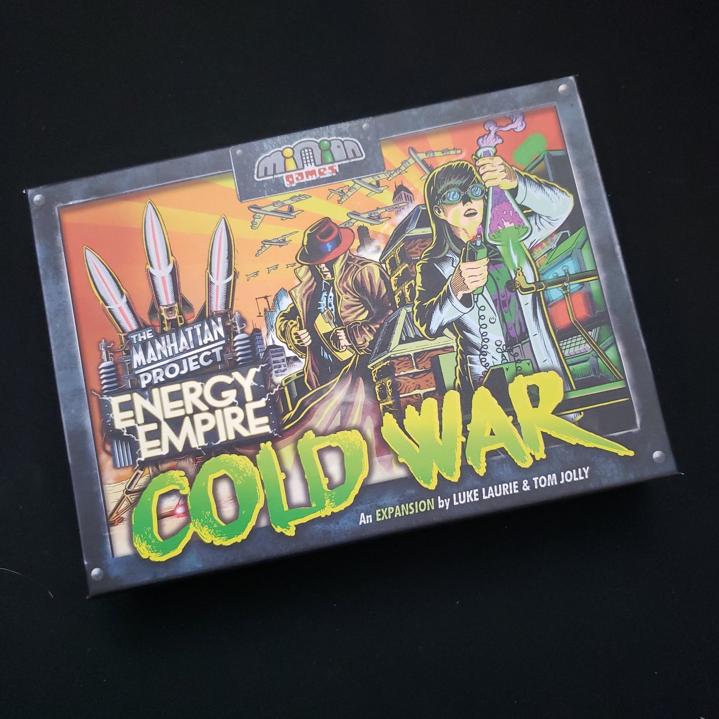 Image shows the front cover of the box of the Cold War expansion for the board game Manhattan Project: Energy Empire