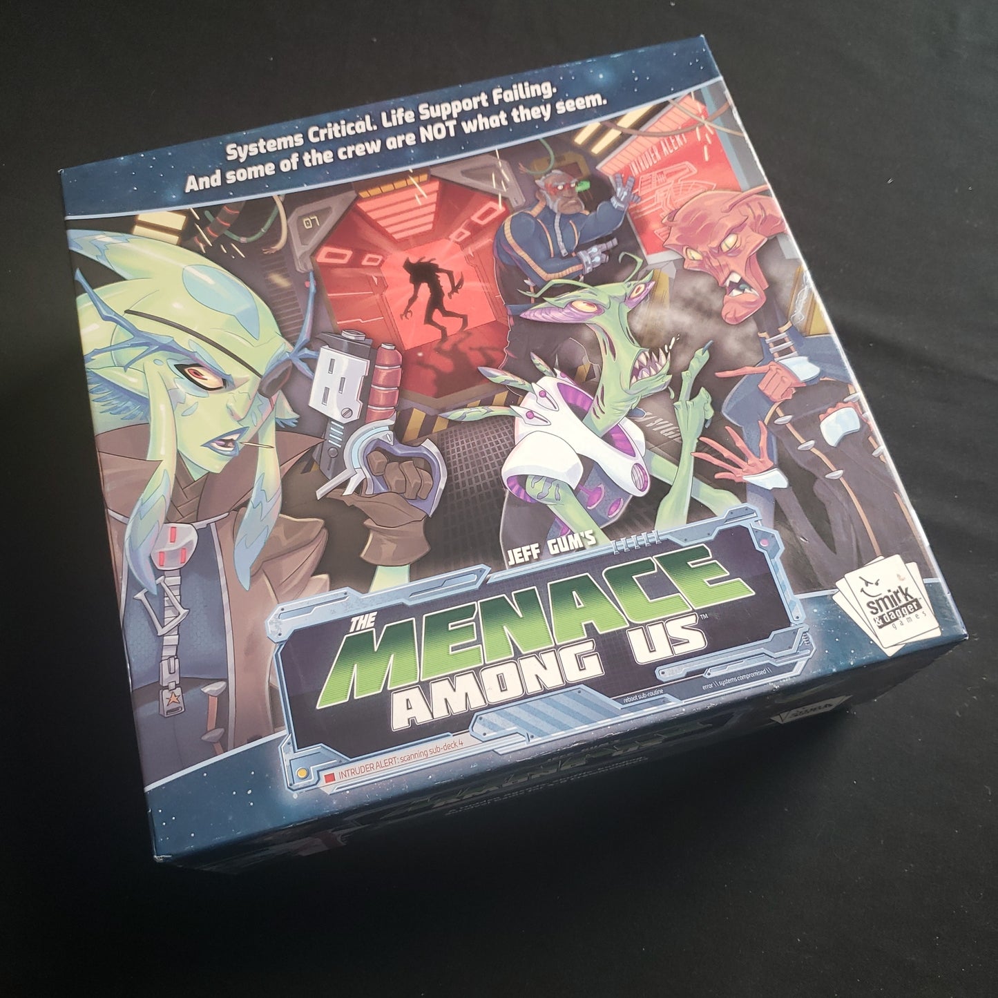 Image shows the front cover of the box of the Menace Among Us card game