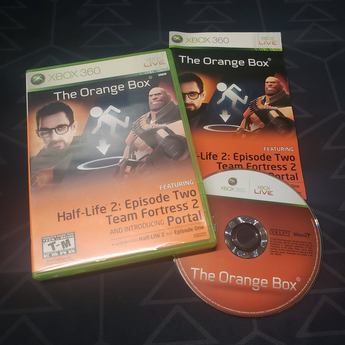Image shows the case, manual and disc for the video game The Orange Box for Xbox 360