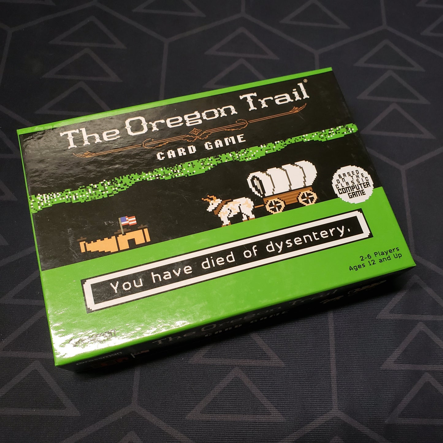 Image shows the front cover of the box of the Oregon Trail card game
