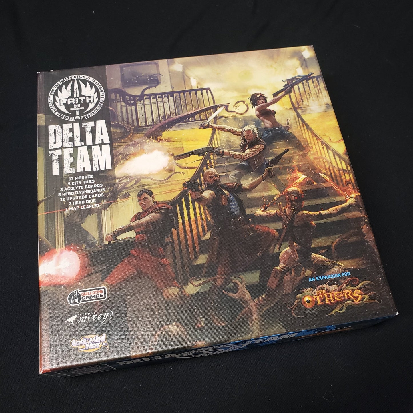 Image shows the front cover of the box of the Delta Team expansion for the board game The Others