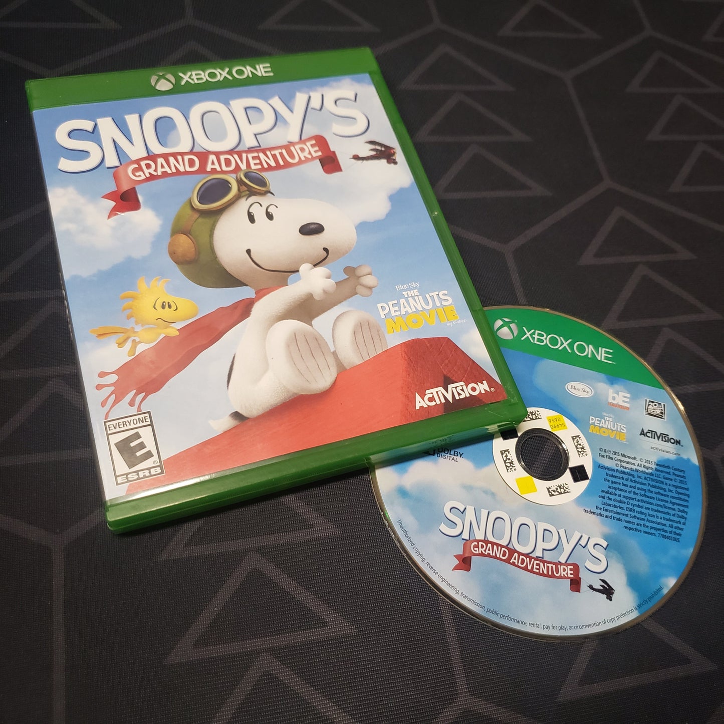Image shows the case and disc for the video game The Peanuts Movie: Snoopy's Grand Adventure for Xbox One