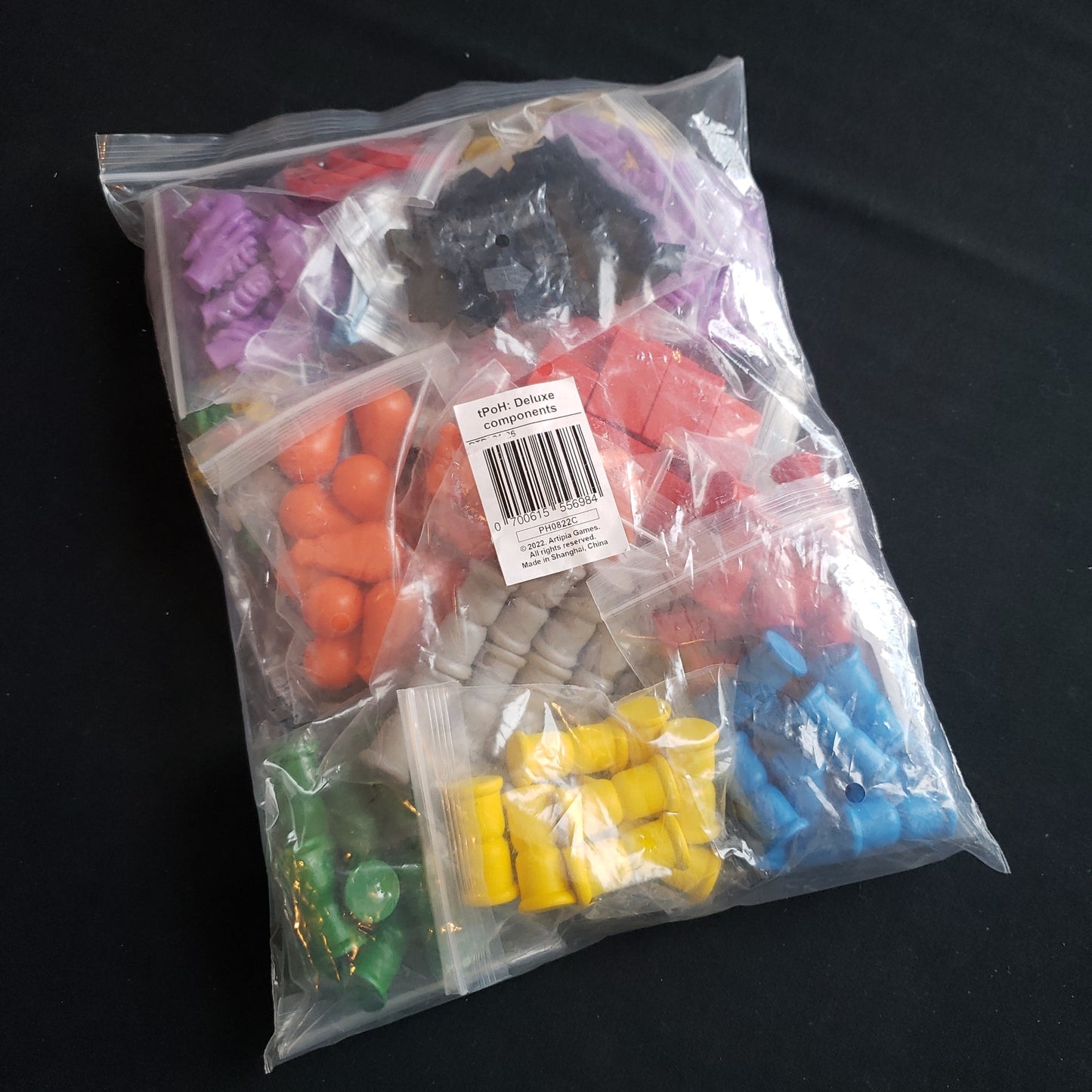 Image shows a bag of wood & resin upgrade components for the Pursuit of Happiness board game