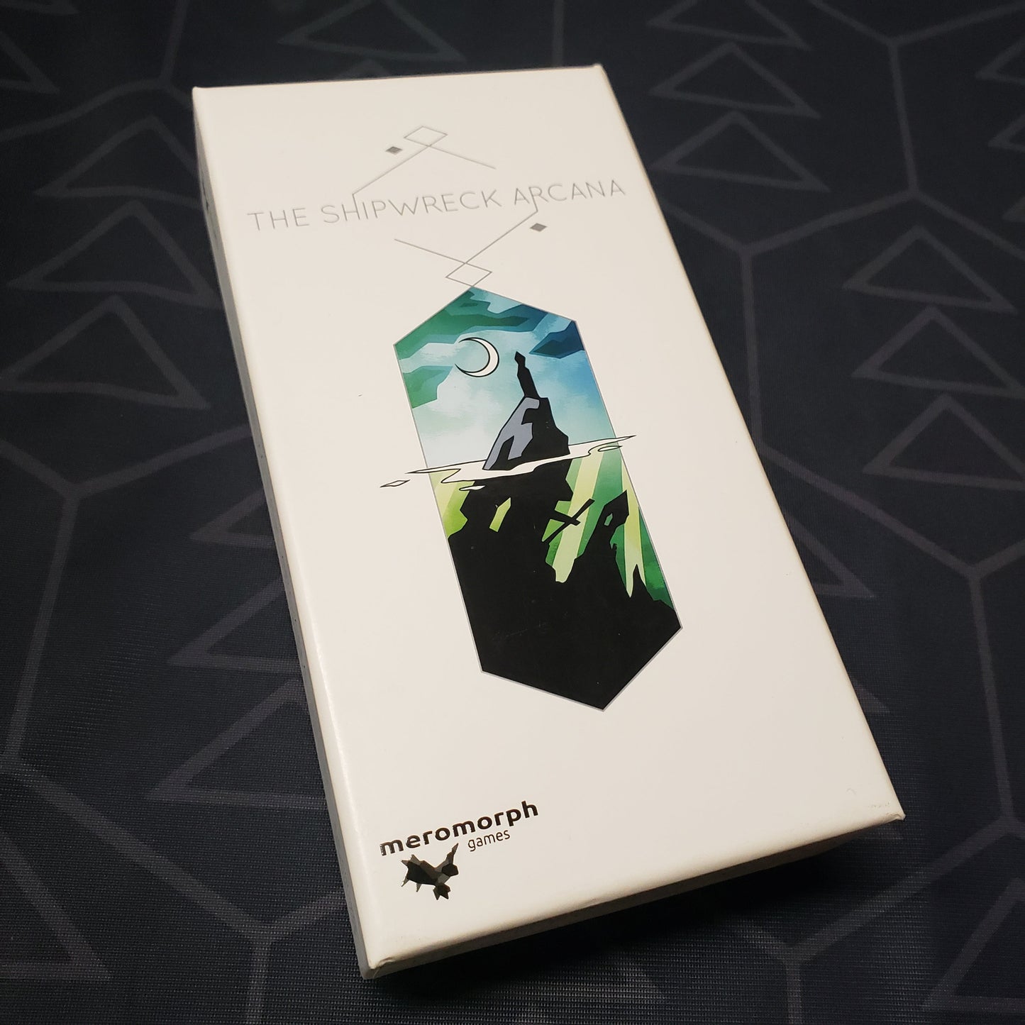 Image shows the front cover of the box of the Shipwreck Arcana card game