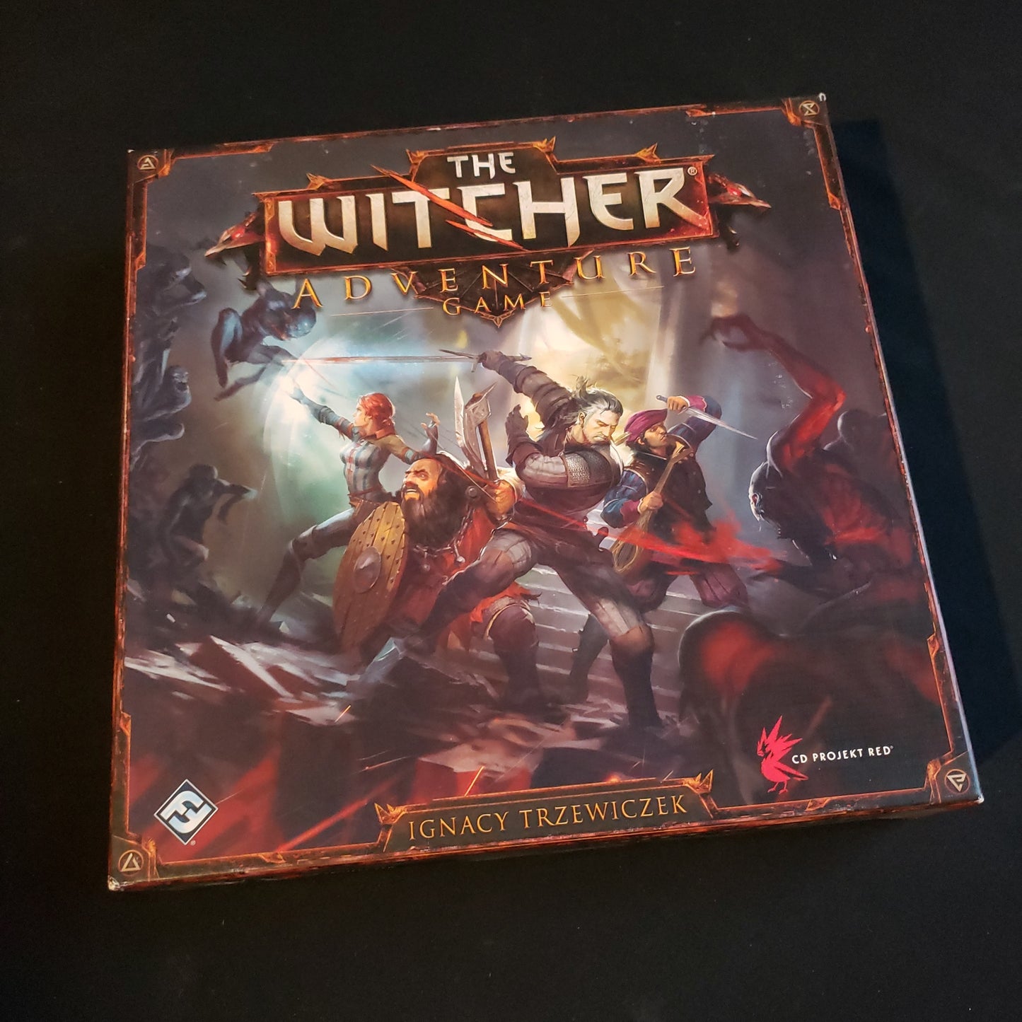 Image shows the front cover of the box of the Witcher Adventure board game