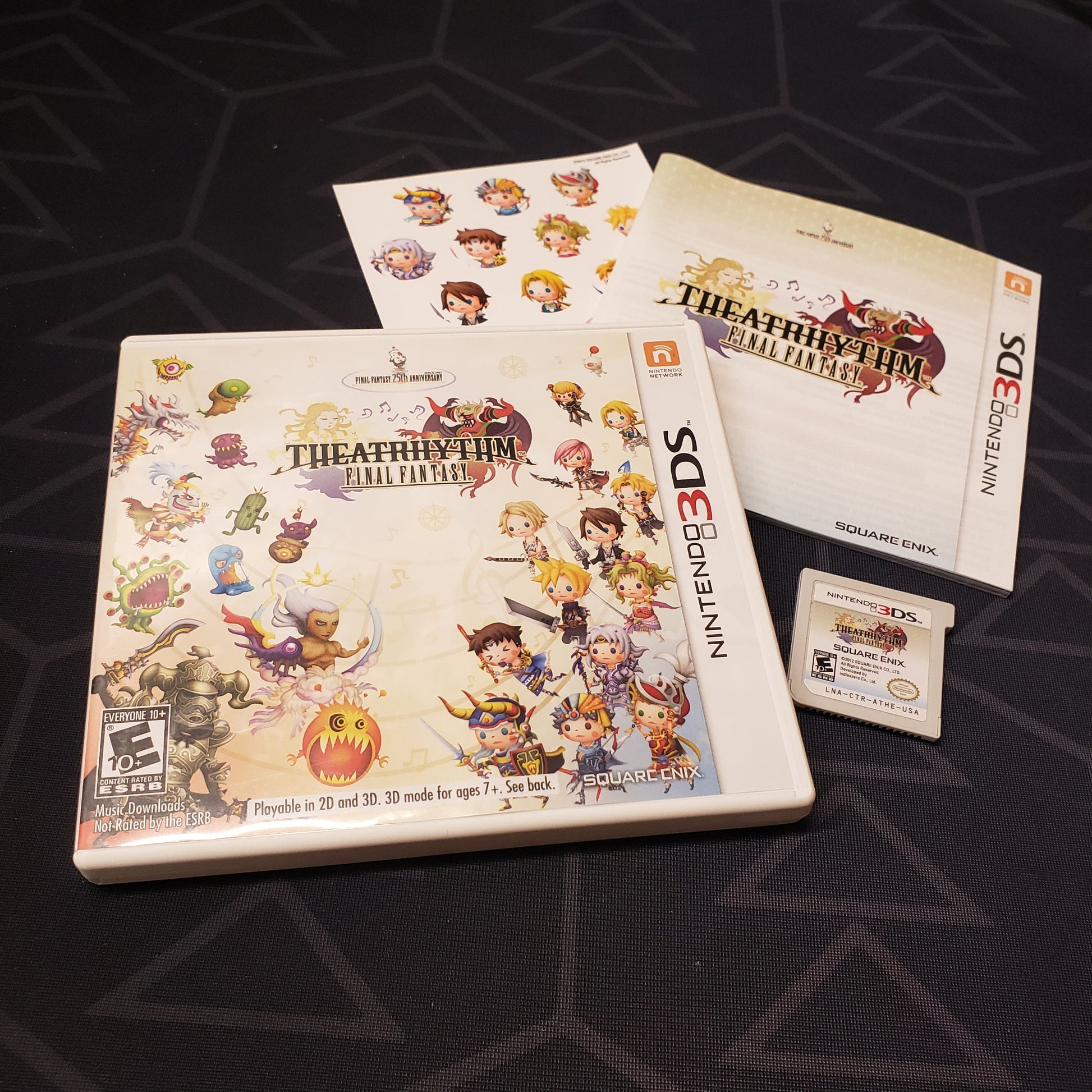 Image shows the case, manual, unused sticker sheet and cartridge for the video game Theatrhythm: Final Fantasy for Nintendo 3DS