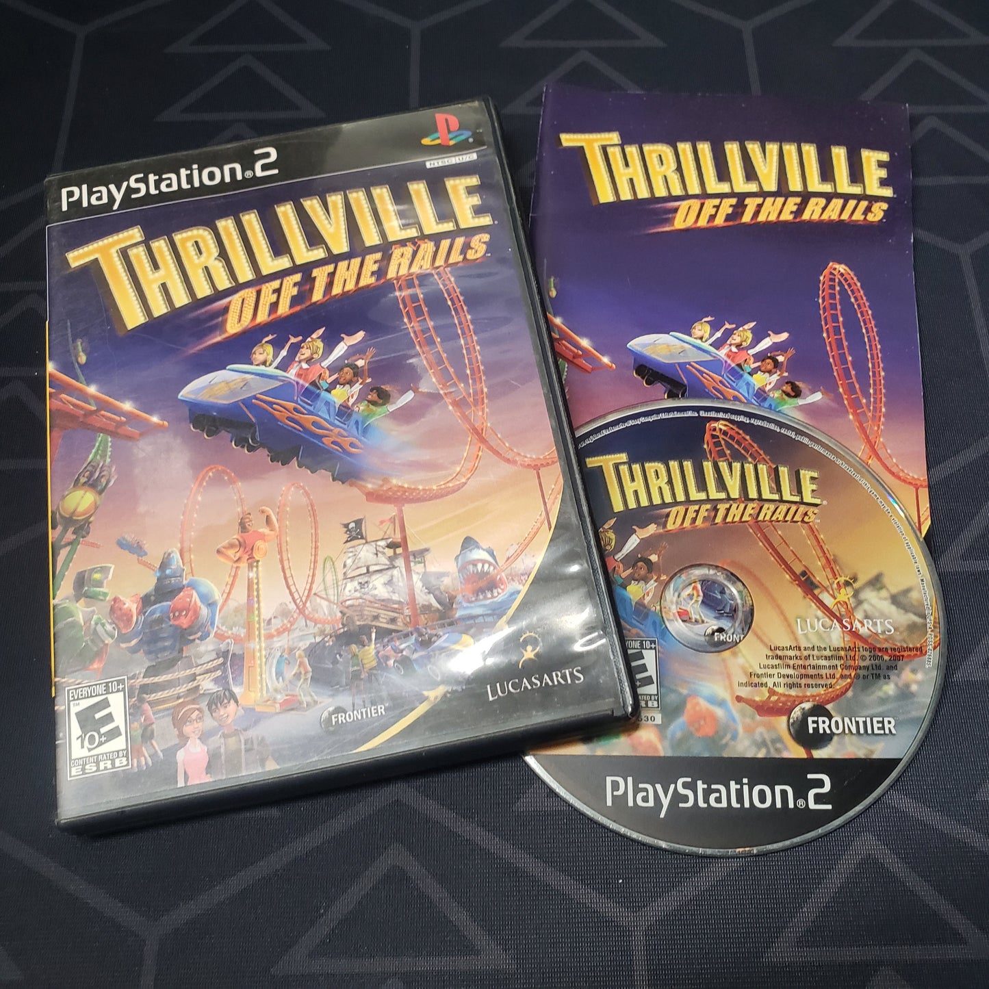 Image shows the case, manual & disc for the video game Thrillville: Off the Rails for Playstation 2