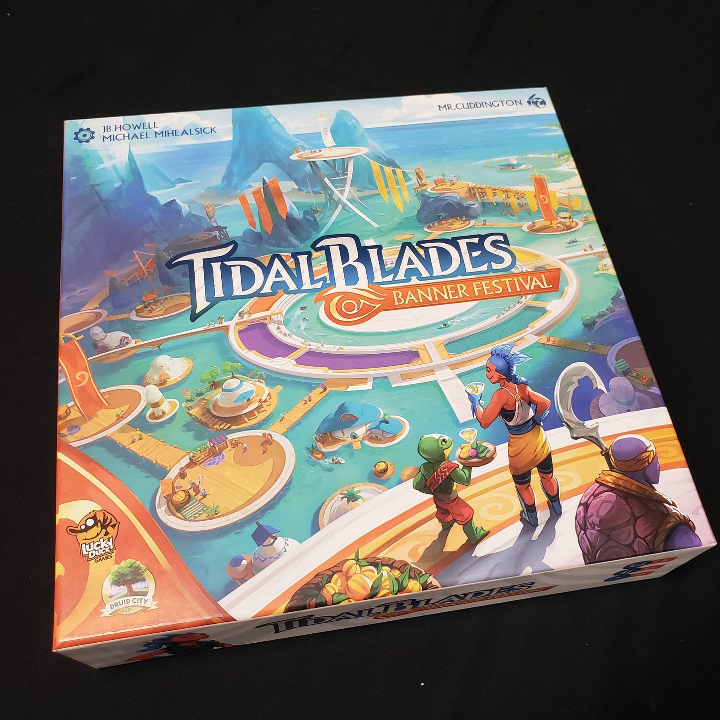 Image shows the front cover of the box of the Tidal Blades: Banner Festival board game