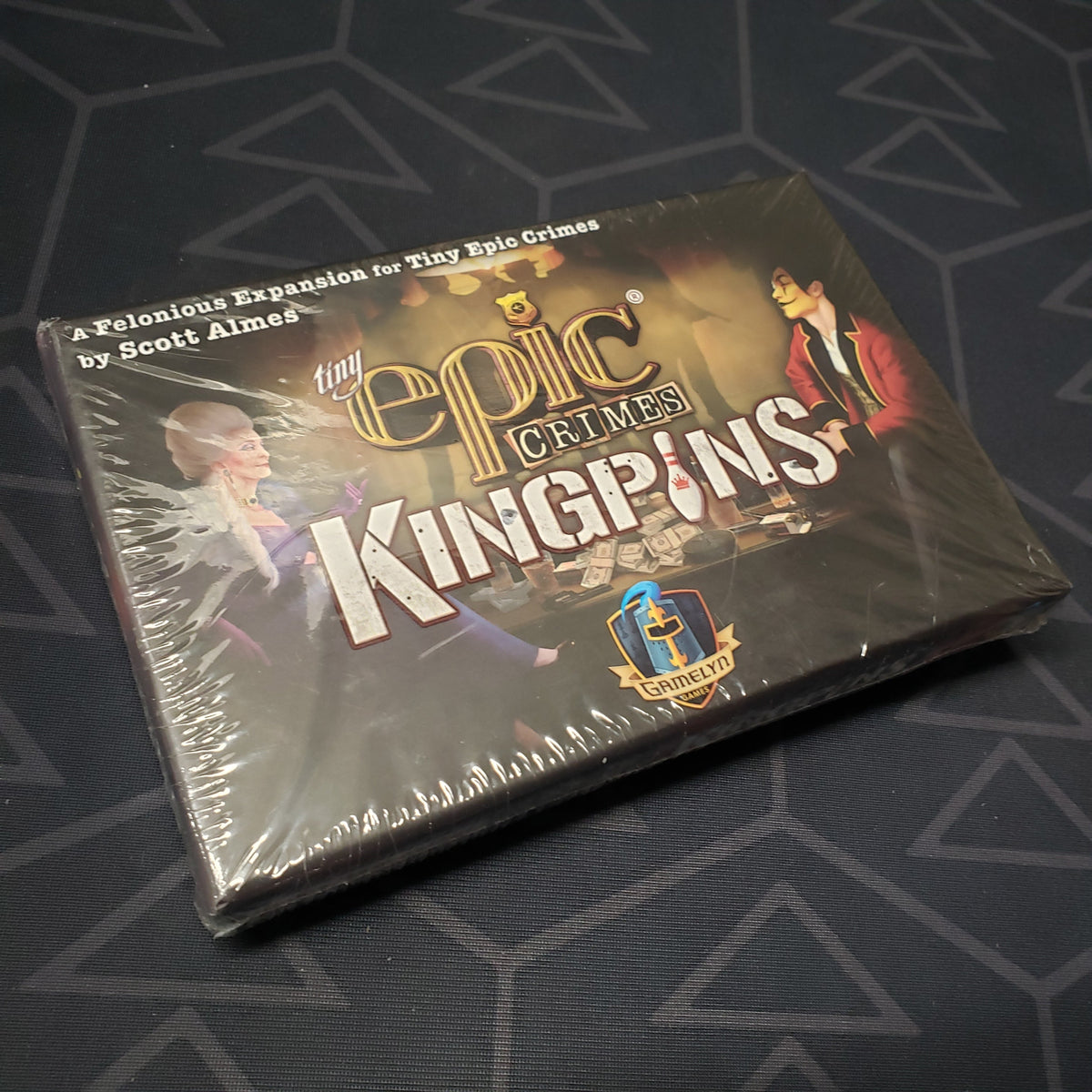 Image shows the front cover of the box of the Kingpins expansion for the board game Tiny Epic Crimes