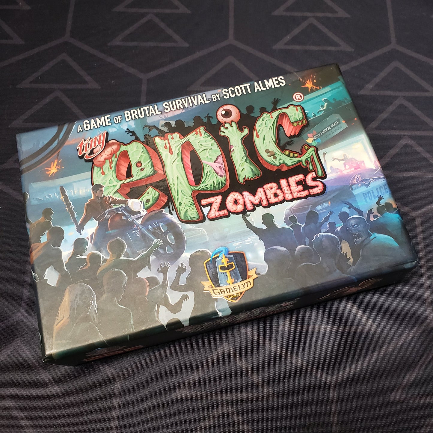 Image shows the front cover of the box for the Tiny Epic Zombies board game