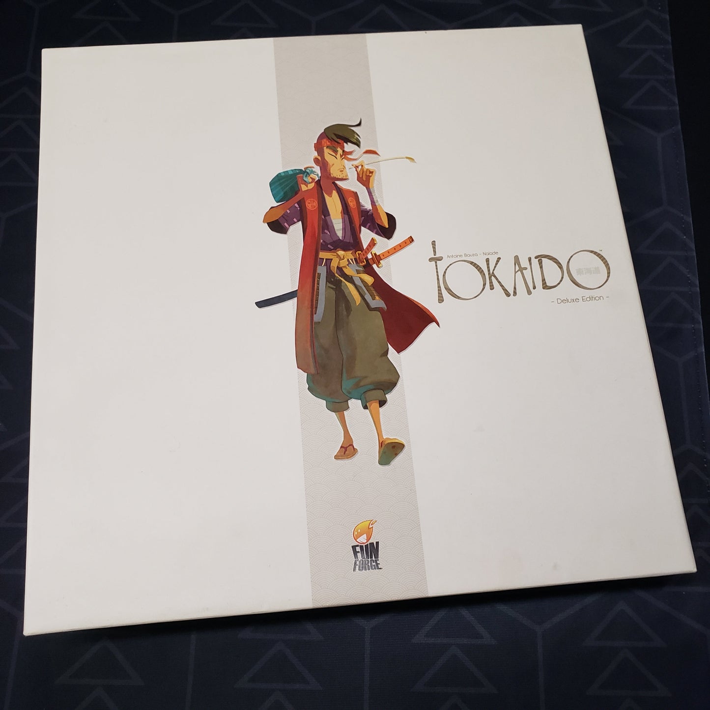 Image shows the front cover of the box for the Tokaido: Deluxe Edition board game