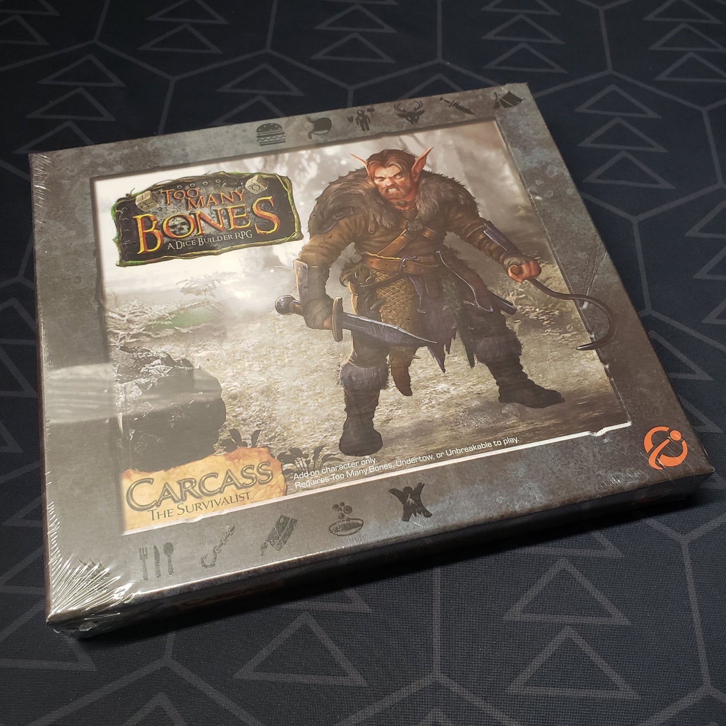 Image shows the front cover of the box for the Carcass expansion from the board game Too Many Bones