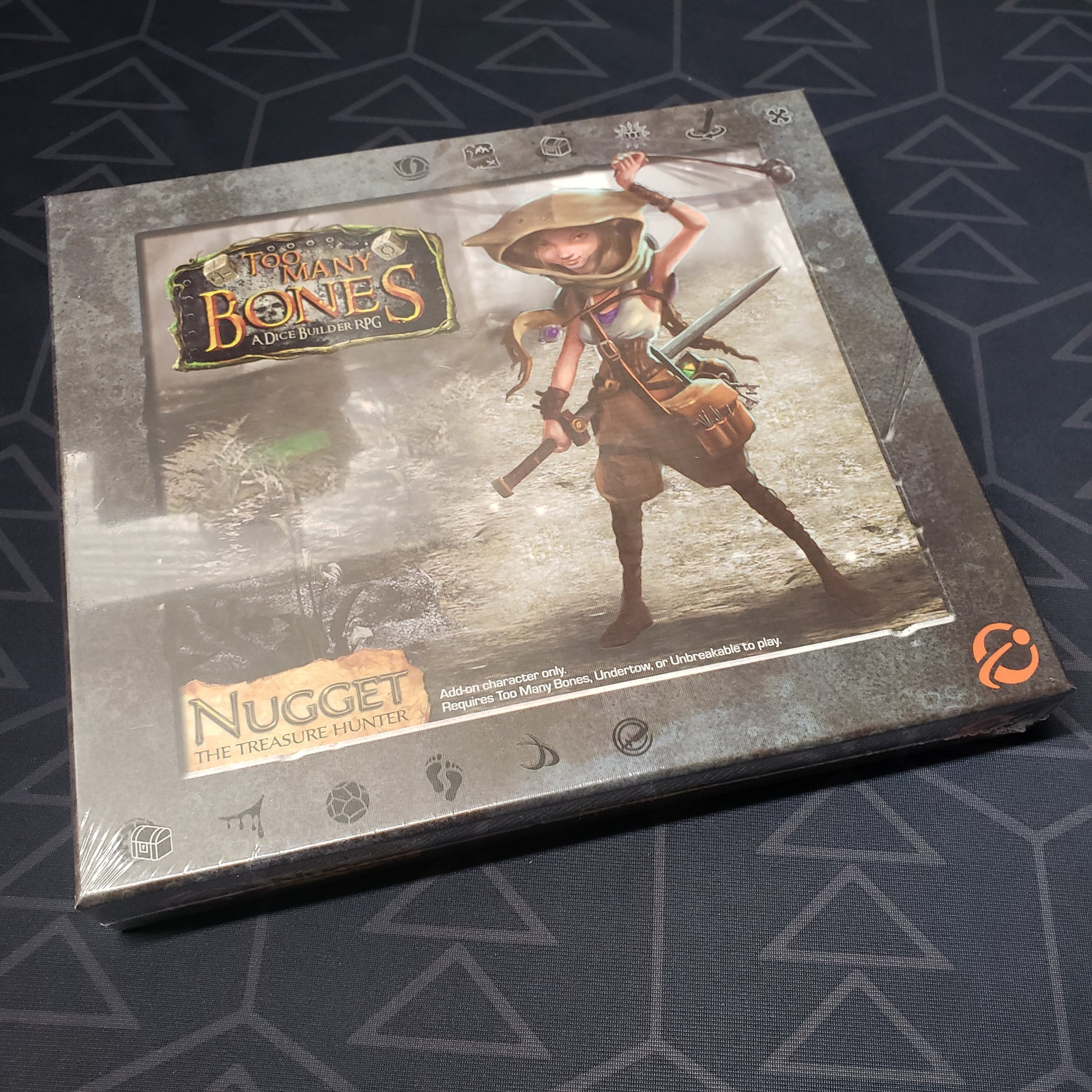 Image shows the front cover of the box for the Nugget expansion from the board game Too Many Bones
