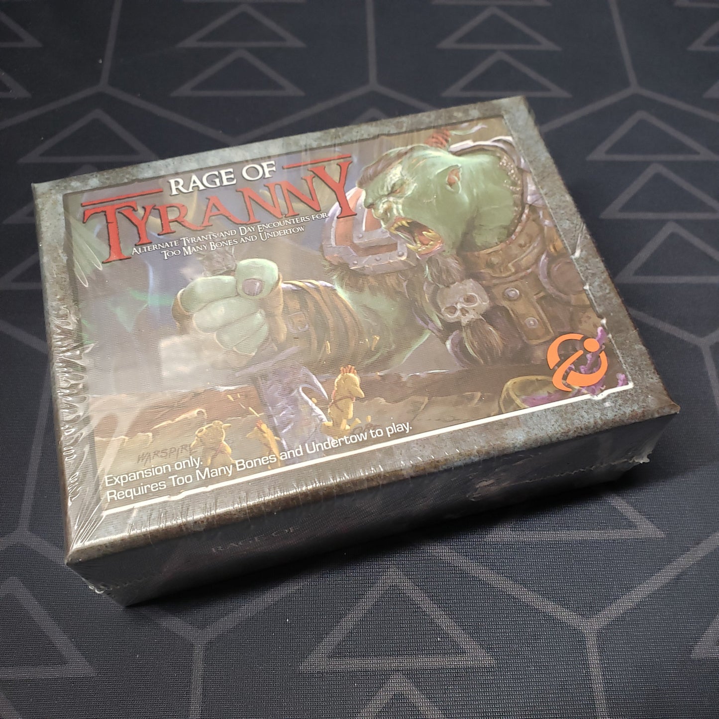 Image shows the front of the box for the Rage of Tyranny expansion for the board game Too Many Bones