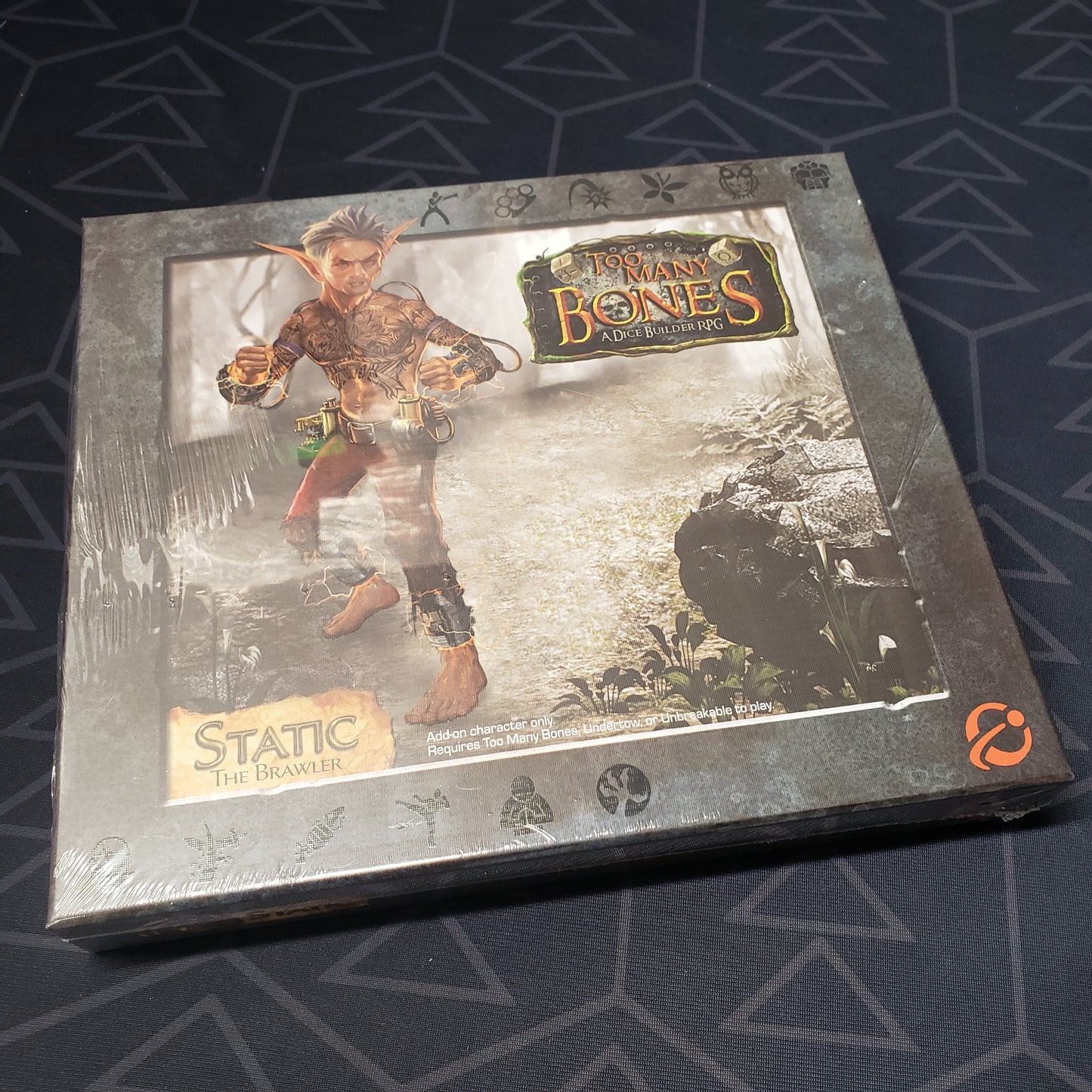 Image shows the front cover of the box for the Static expansion from the board game Too Many Bones