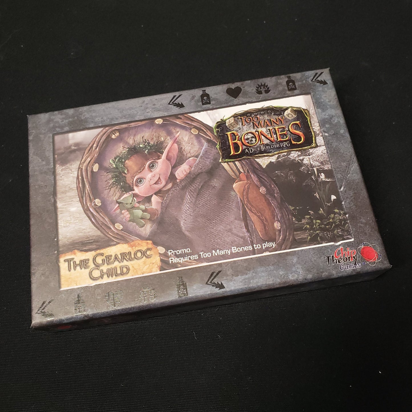 Image shows the front of the box for the Gearloc Child expansion for the board game Too Many Bones