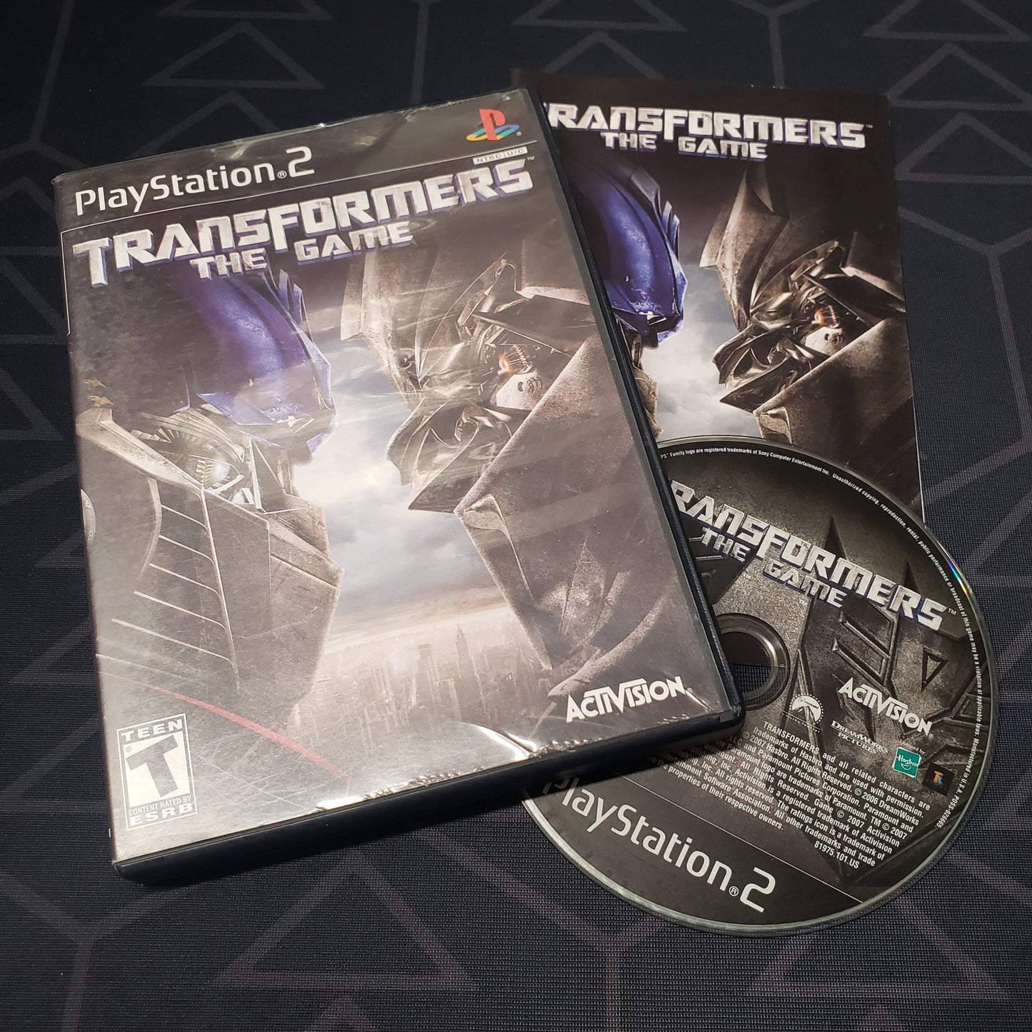 Image shows the case, manual and disc for the video game Transformers: The Game for Playstation 2