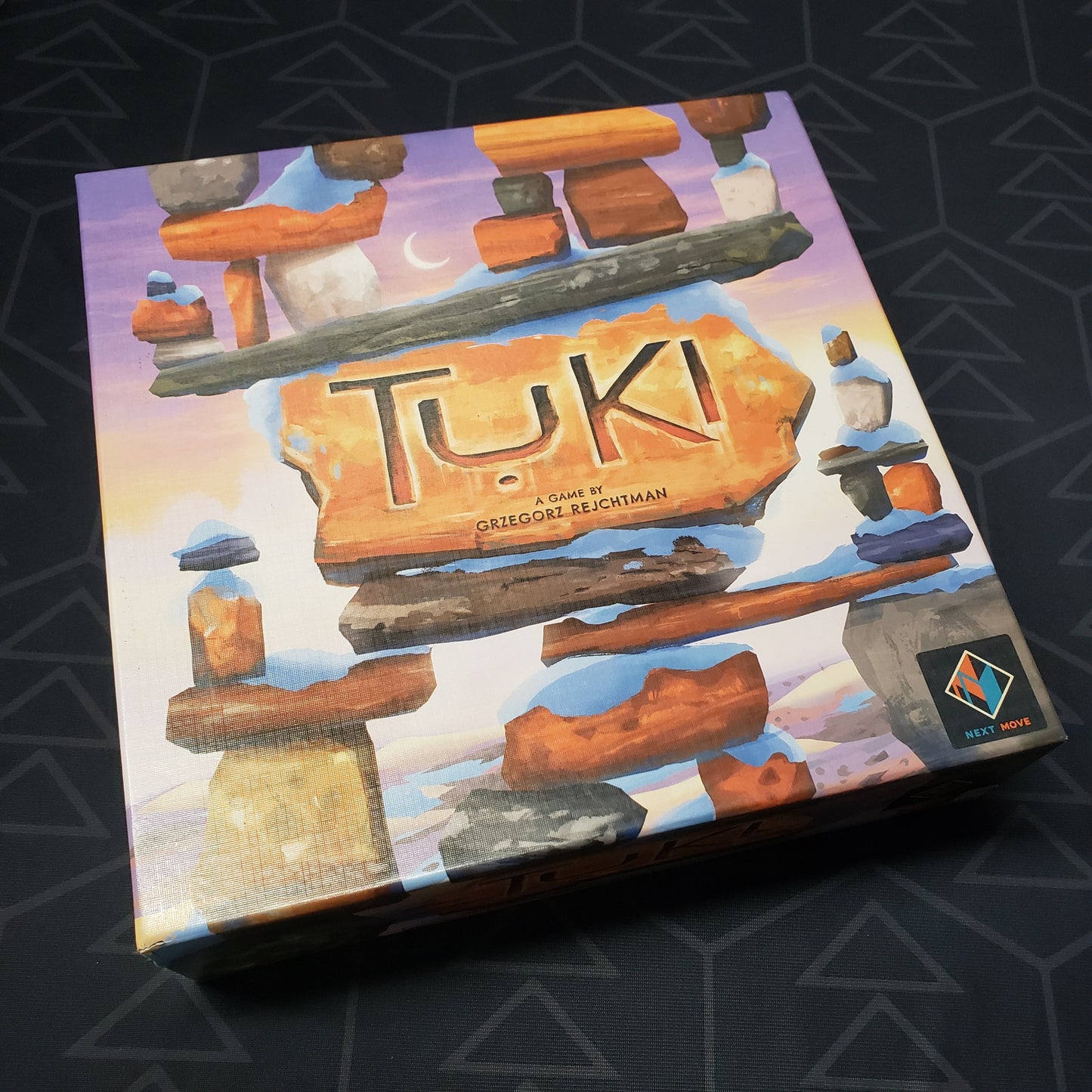 Image shows the front cover of the box for the Tuki board game