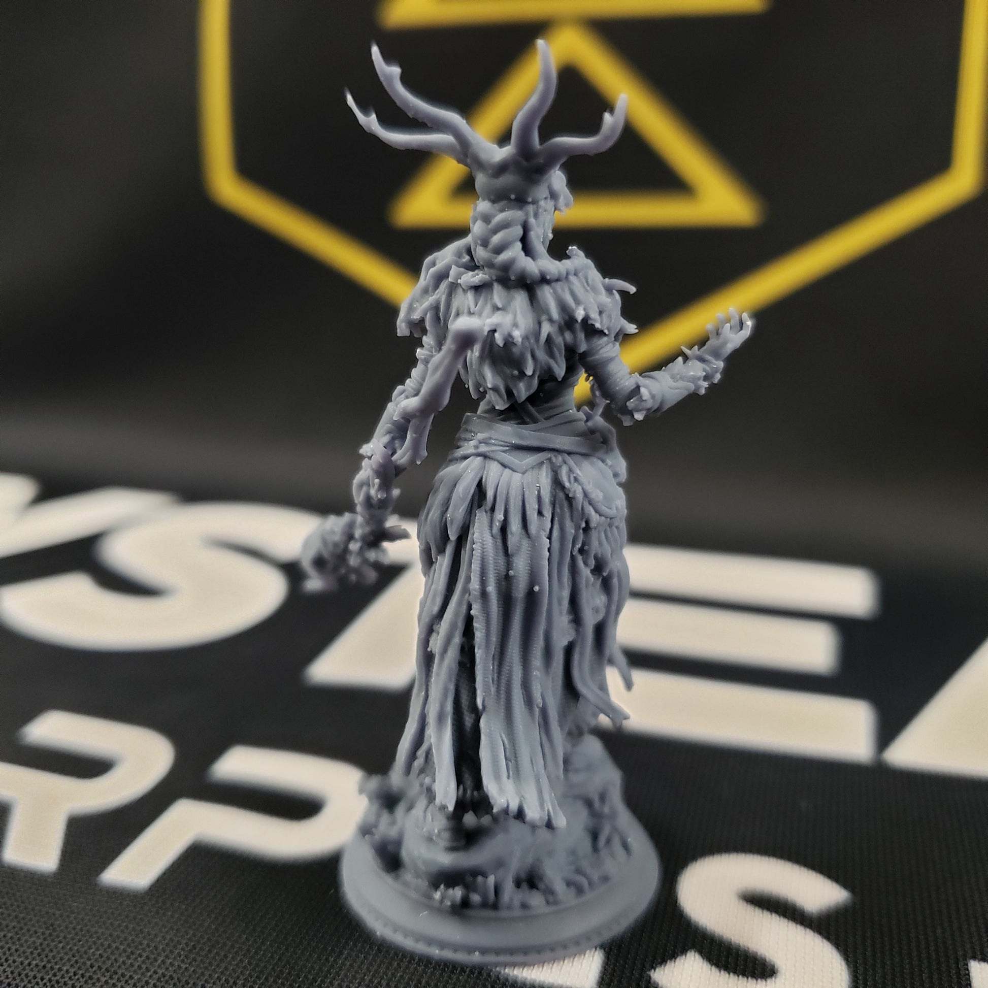 Image shows the back of a 3D printed half-giant druid gaming miniature holding a branch staff