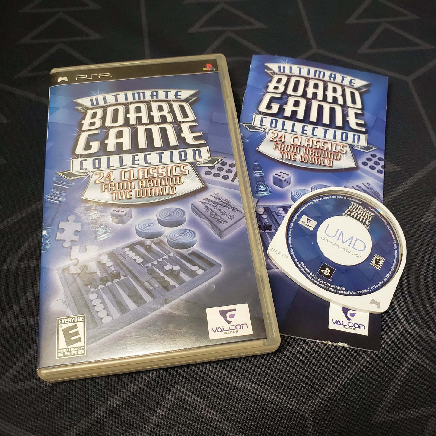 Image shows the case, manual and UMD disc for the video game Ultimate Board Game Collection for Playstation Portable