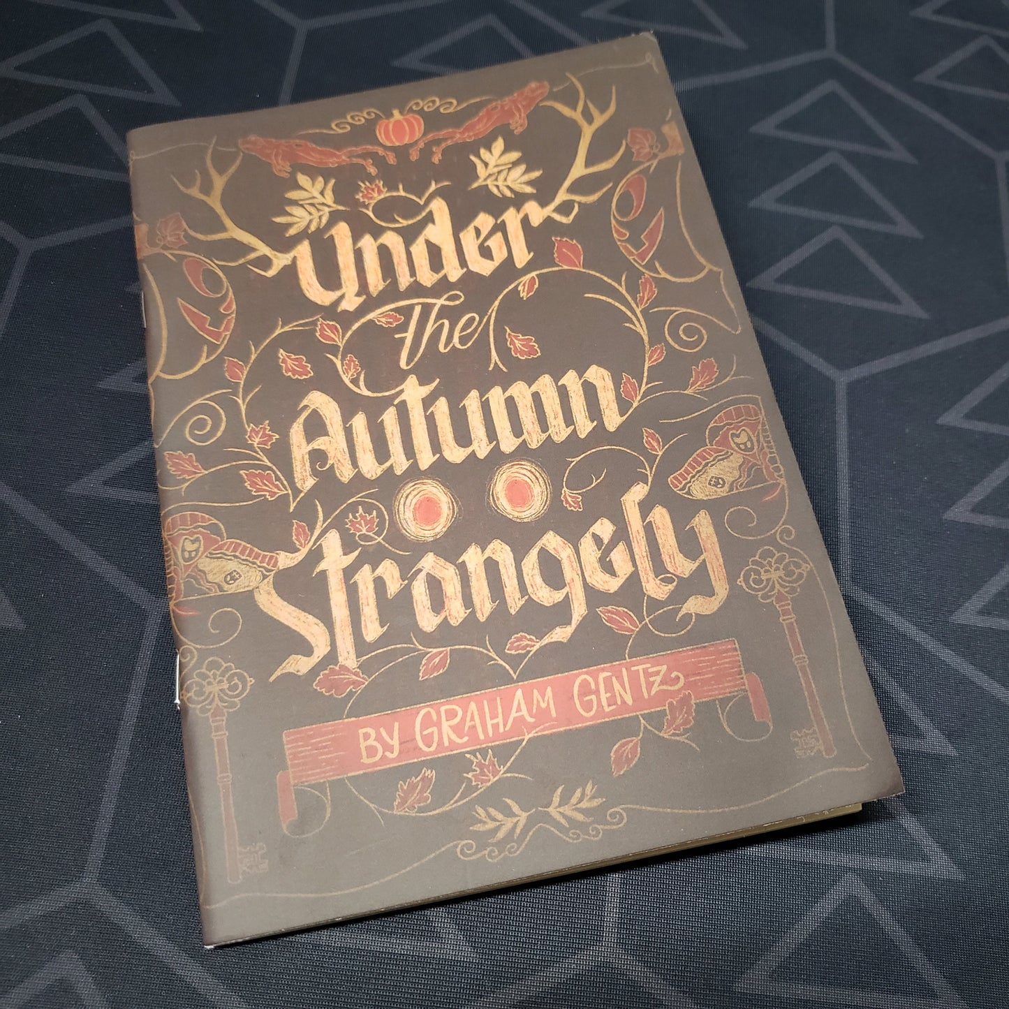 Image shows the front cover of the Under the Autumn Strangely roleplaying game book