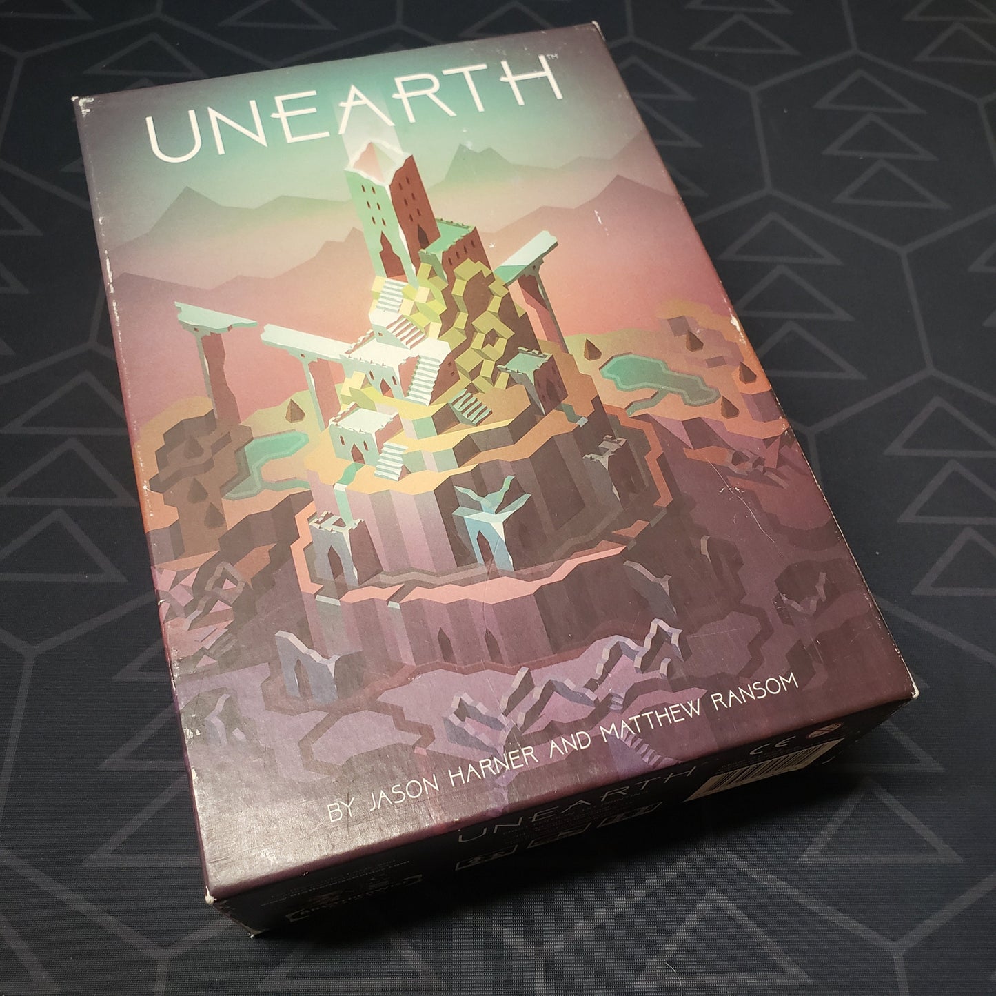 Image shows the front cover of the box of the Unearth board game