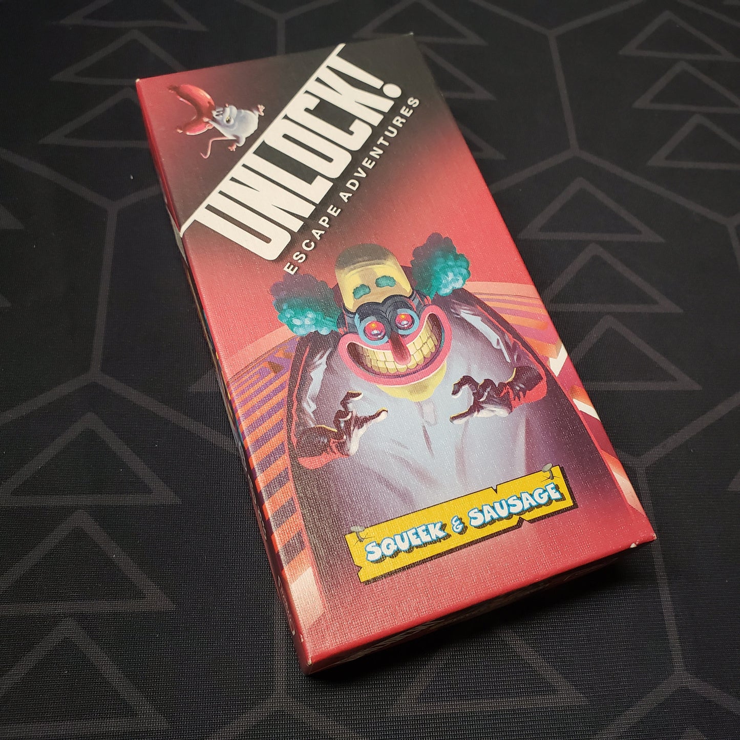 Image shows the front cover of the box of the Unlock!: Squeek & Sausage card game