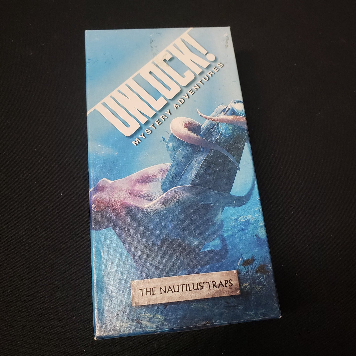 Image shows the front cover of the box of the Unlock!: The Nautilus Traps card game